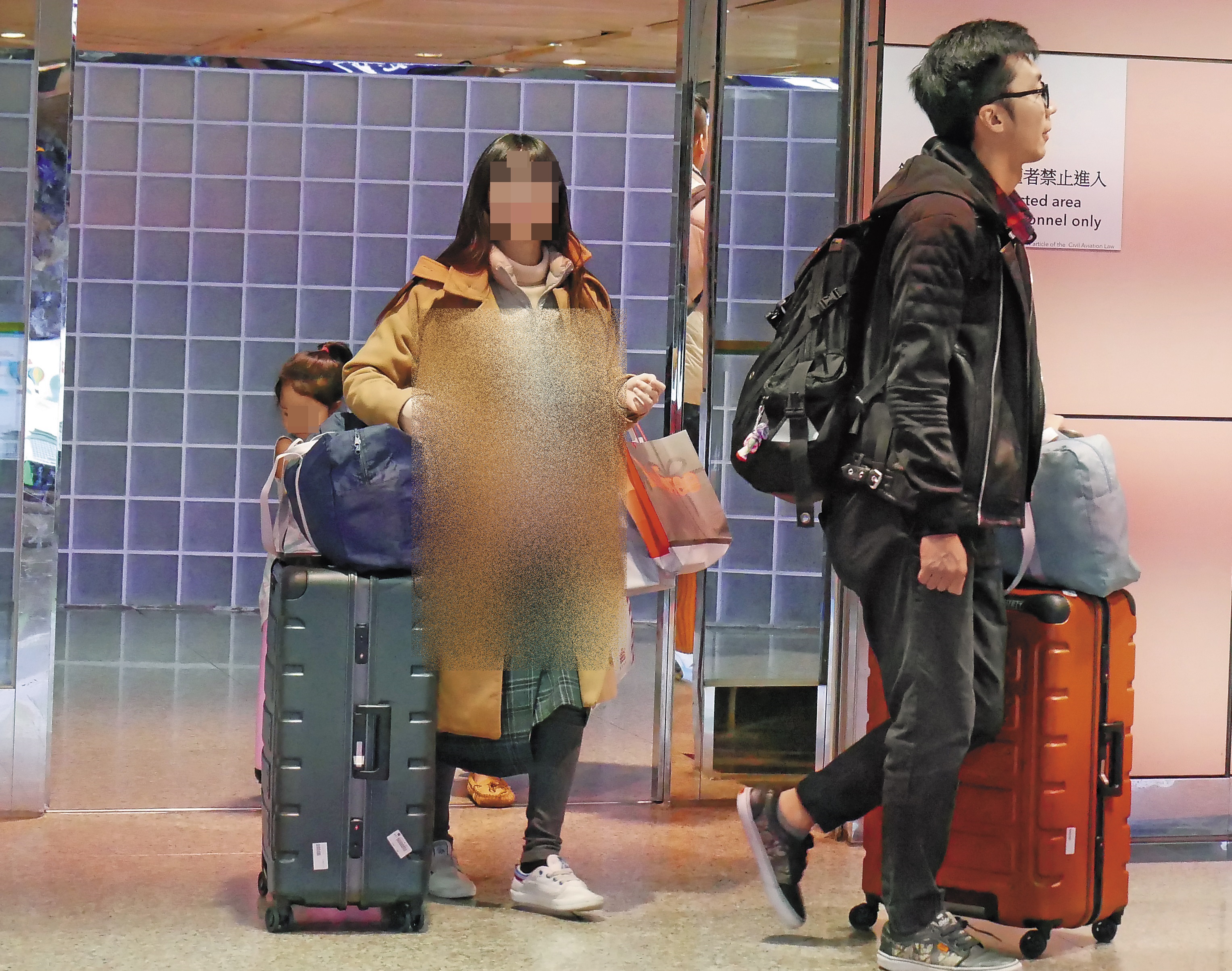 優格姐姐和老公步出機場，明顯可見身材圓潤孕肚藏不住。