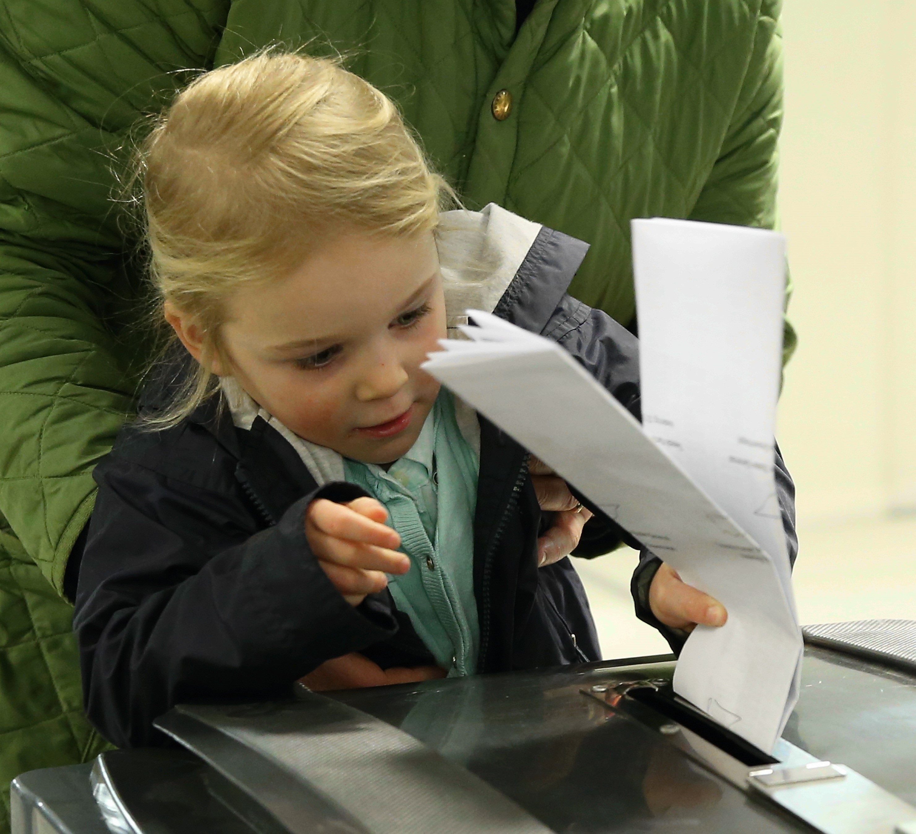 2017年3月15日，荷蘭海牙的投票所，一名小女孩把父親的選票投入票箱。（東方IC）