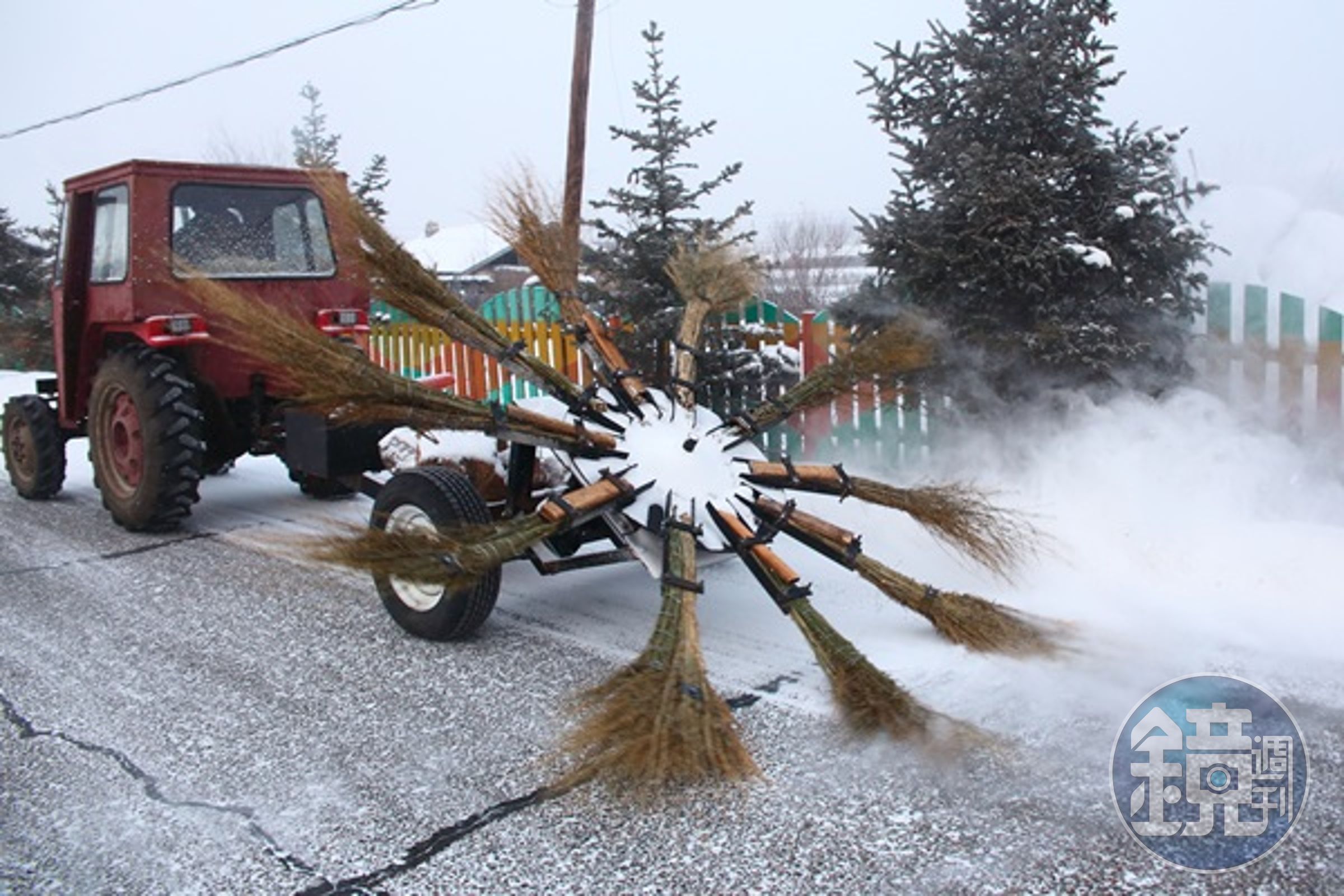 小鎮街道上的掃雪車，將掃把插在轉盤上快速旋轉。 