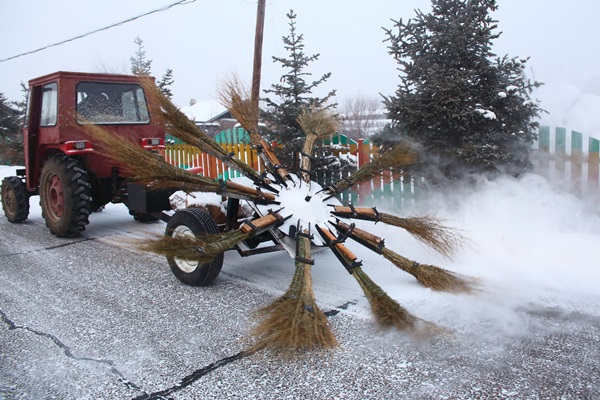 小鎮街道上的掃雪車，將掃把插在轉盤上快速旋轉。 
