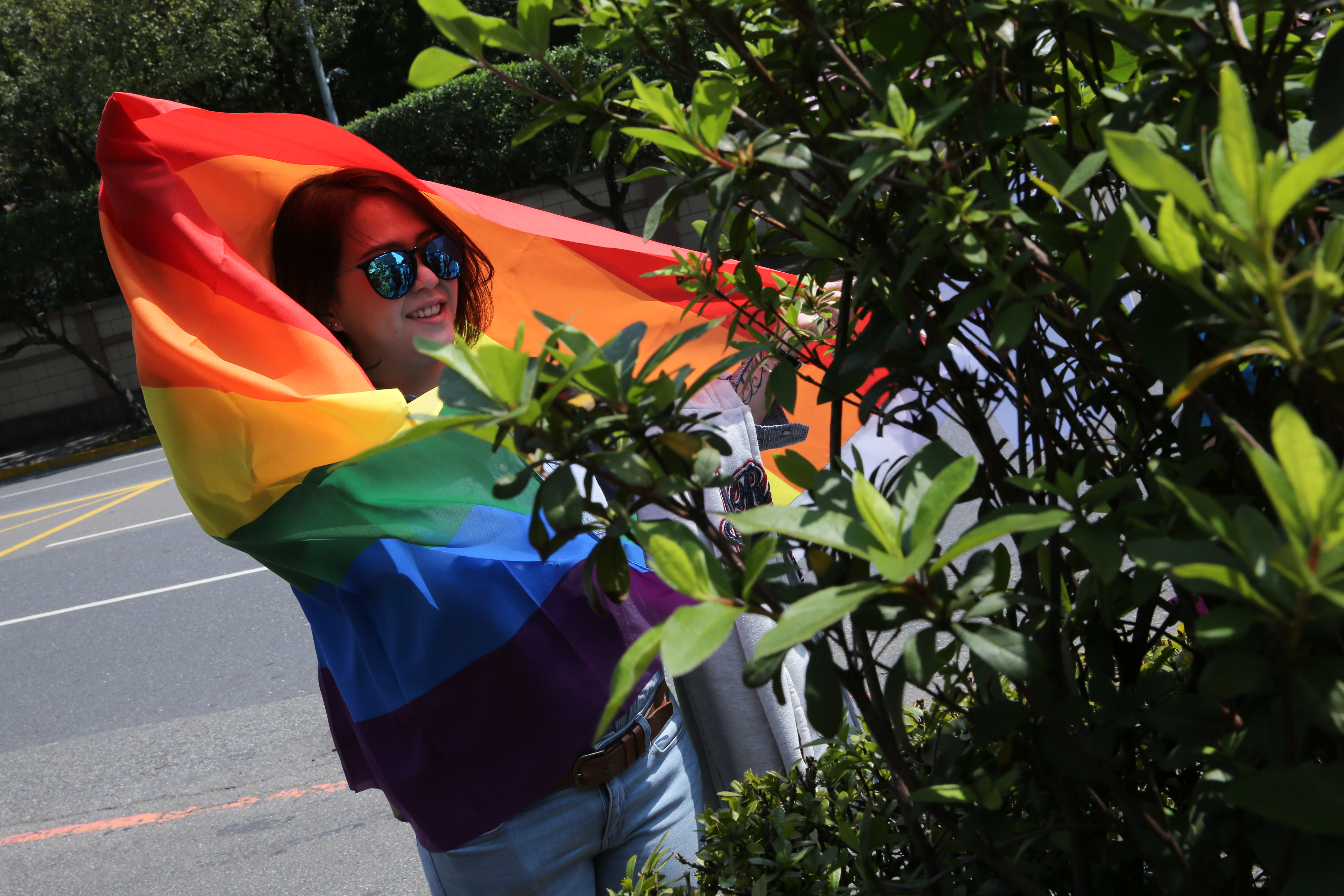 一名女大生身披彩虹旗，到司法院前聲援。