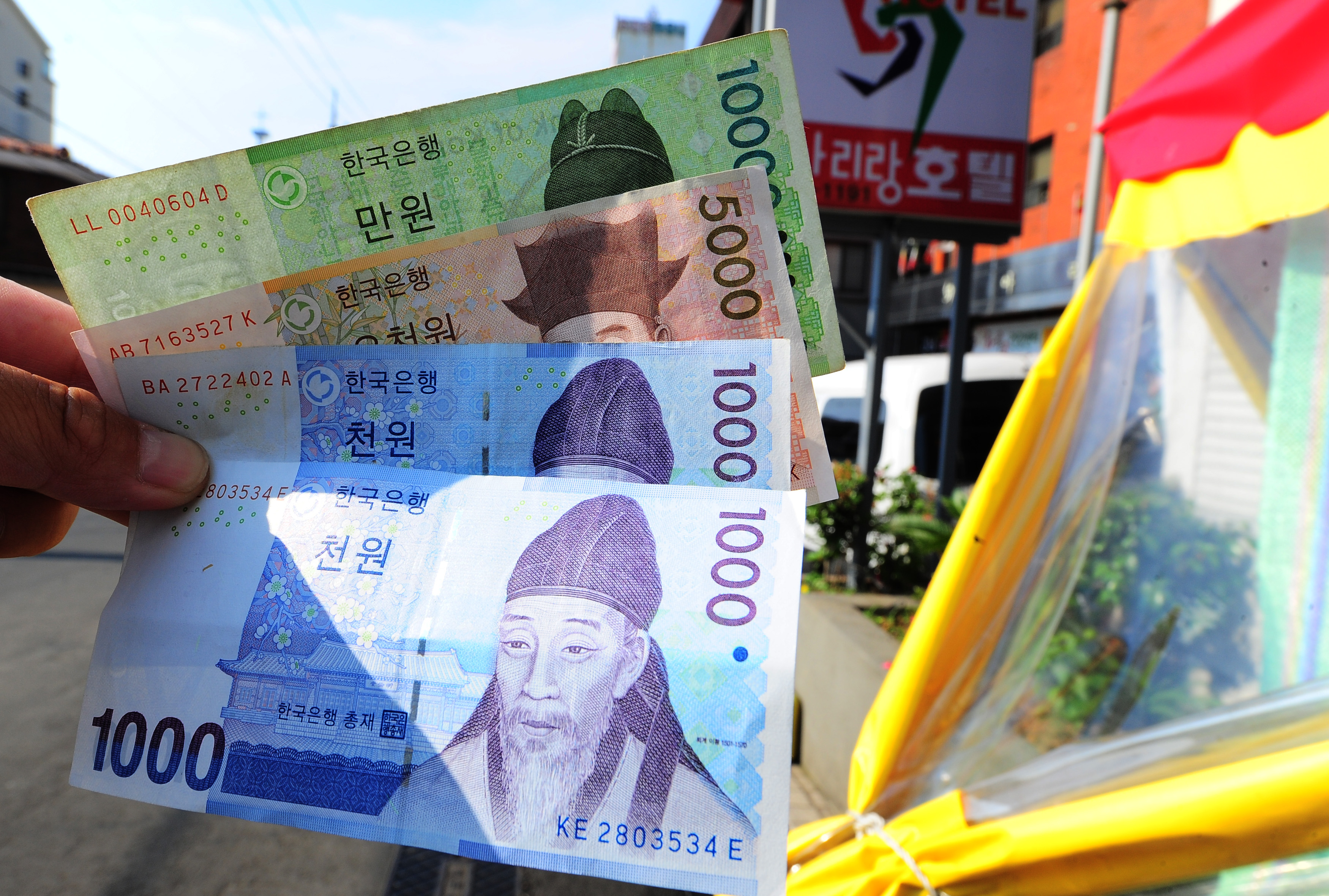 南韓濟州島，觀光客拿著剛剛兌換的韓幣準備上街購物。（東方IC）