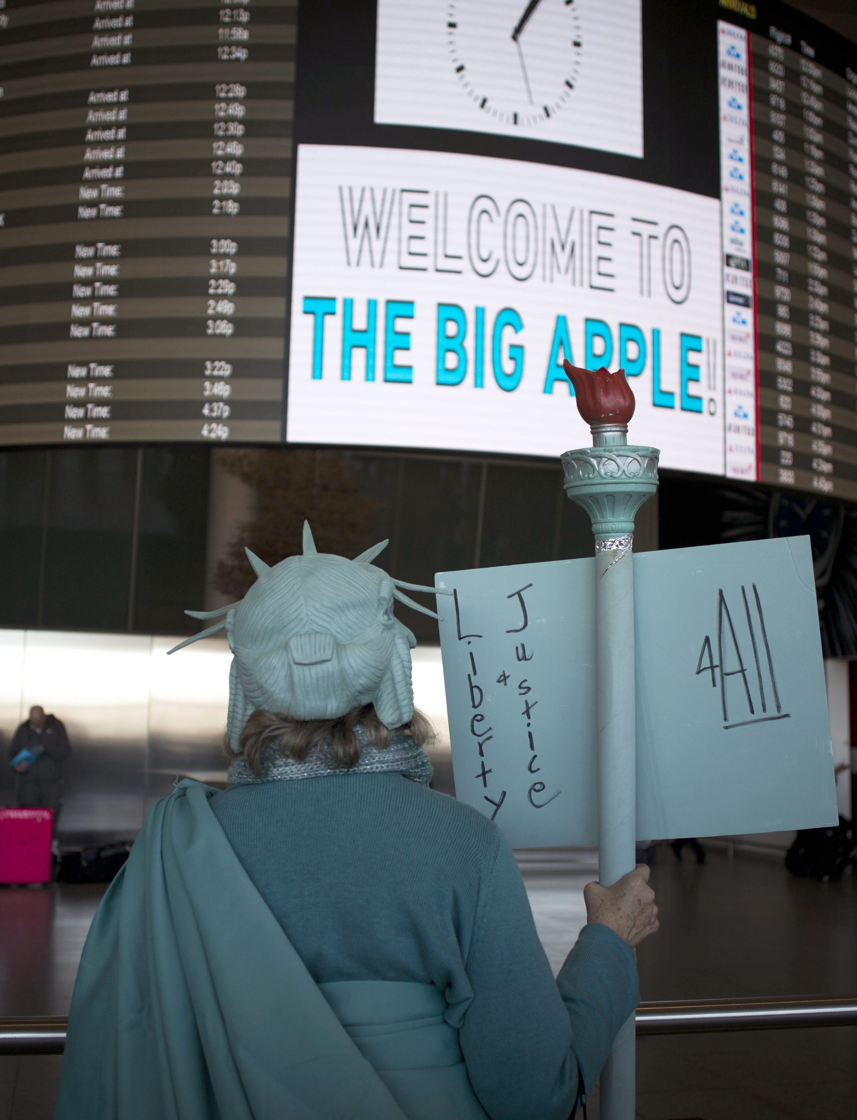 扮成自由女神民眾在紐約甘迺迪機場出境大廳抗議川普的穆斯林禁航令。（東方IC）