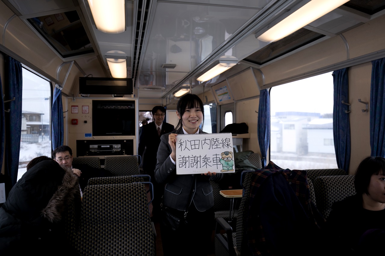 隨車的女性車掌用自製繪本向台灣乘客打招呼。