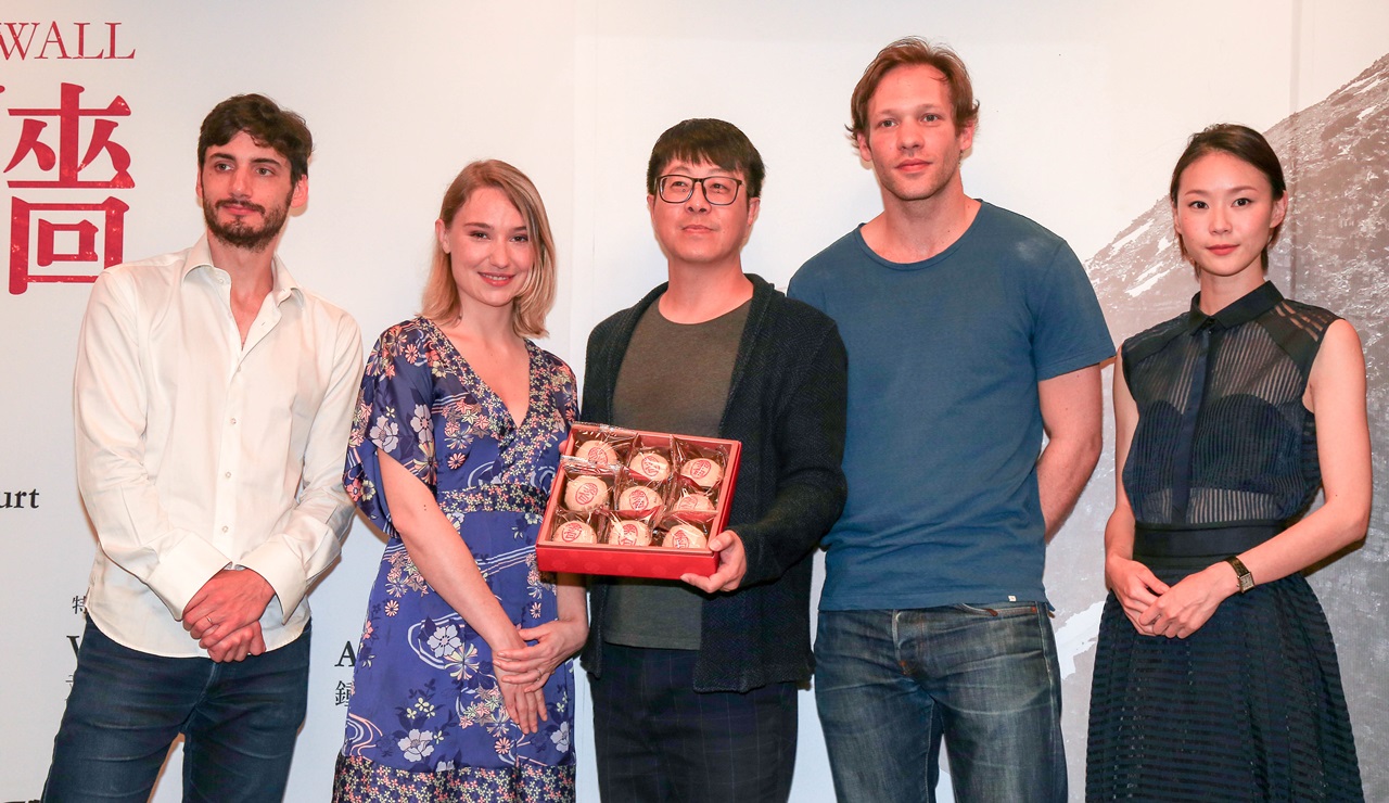 高雄市文化局長尹立（中間）以在地的綠豆椪，歡迎《愛之牆》劇組來高雄拍戲。