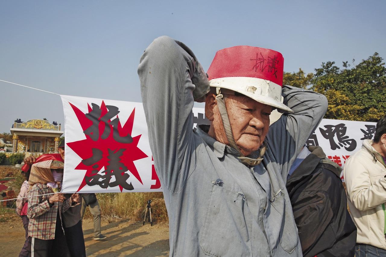 受害地主頭綁抗議紅布條,怒批政府執意劃分土地又不徵收,太過蠻橫。