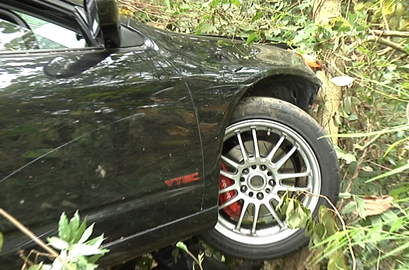 黑車車頭撞樹凹陷引擎蓋也翹起來，毀損嚴重。