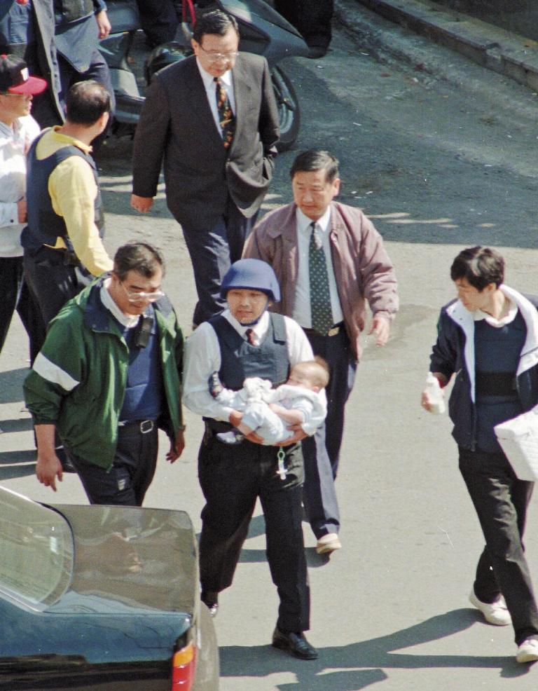 陳進興持槍挾持南非武官卓懋祺一家6口，現為新北市副市長的侯友宜（右）與台北市警察局長邱豐光（左），當時冒險進屋抱出小孩。（達志影像）
