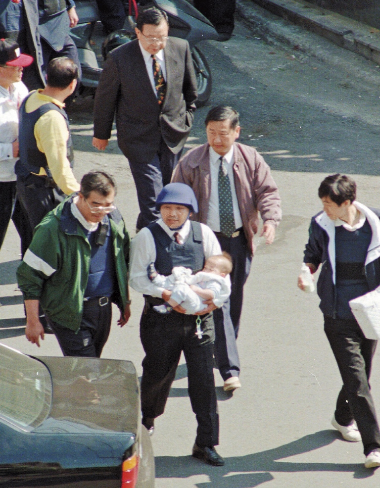 陳進興持槍挾持南非武官卓懋祺一家6口,現為新北市副市長的侯友宜(右)與台北市警察局長邱豐光(左),當時冒險進屋抱出小孩。(達志影像)
