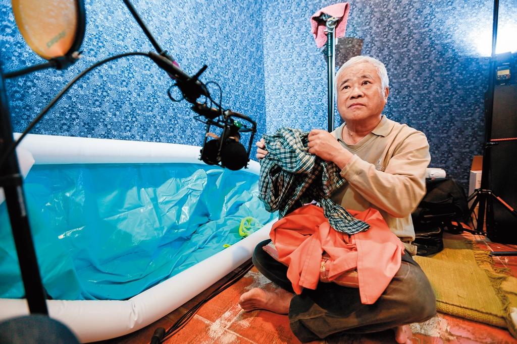 胡定一在錄音室內緊盯螢幕,配合畫面做出各種聲音,如圖中他錄下衣服抖動的音效。