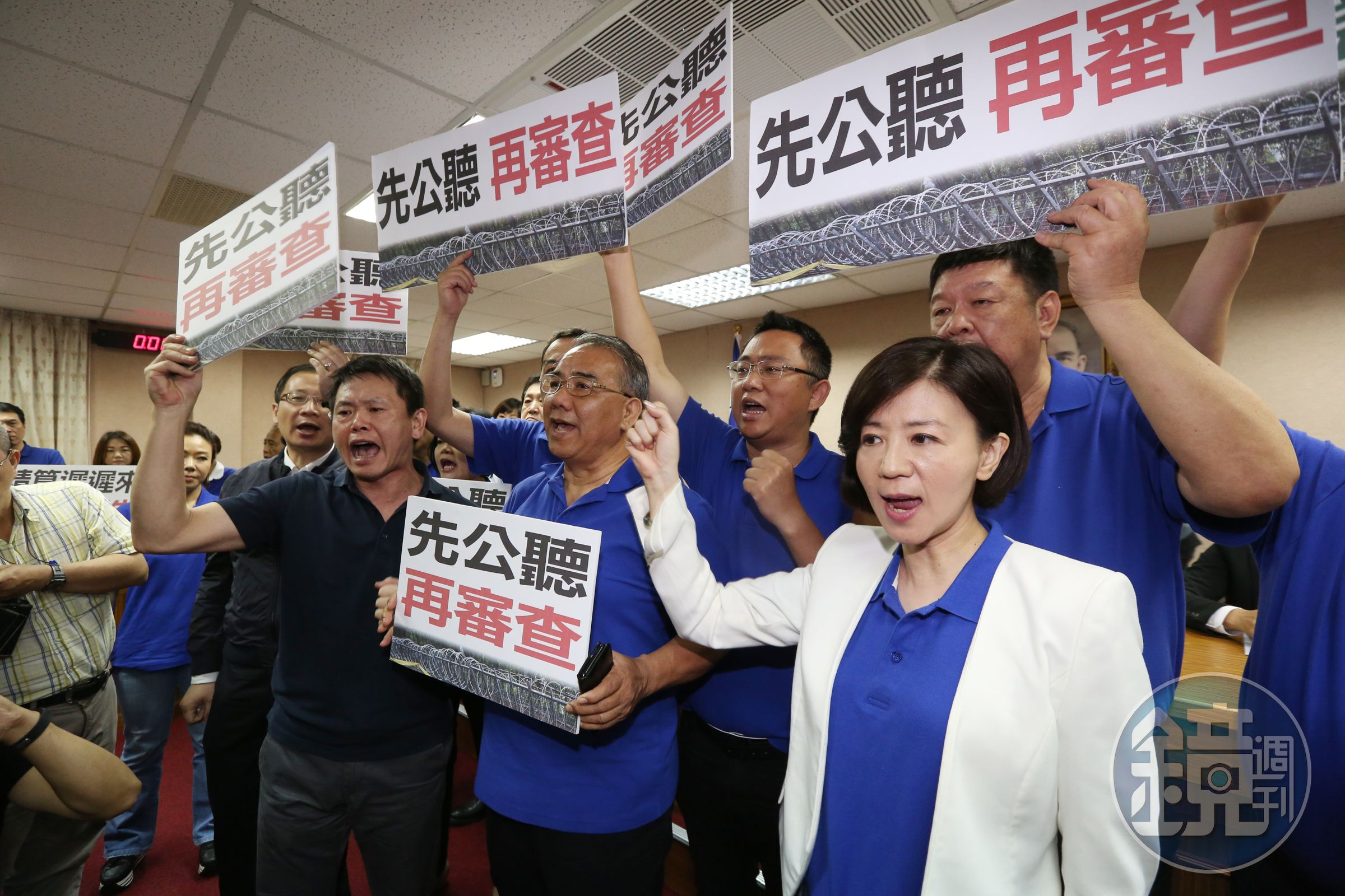 國民黨立委上前包圍主席台，舉抗議標語高喊：「先公聽再審查！」