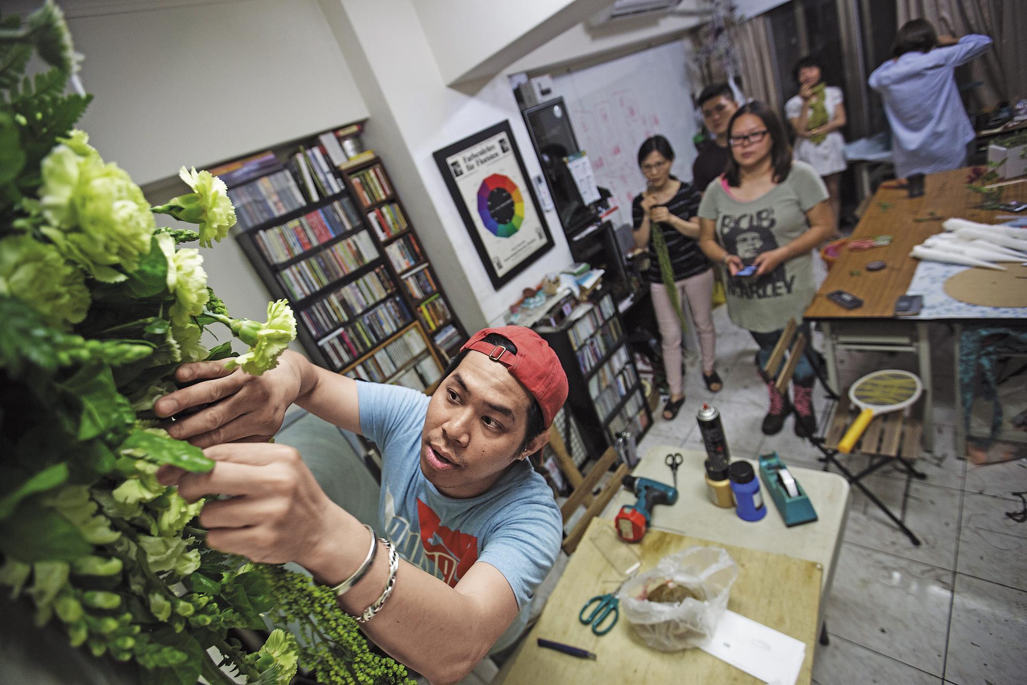 吳尚洋的花藝課總是從下午上到隔天凌晨,來自台北、台中和台南的學生仍絡繹不絕。圖為他在為學生的花藝作品做調整。