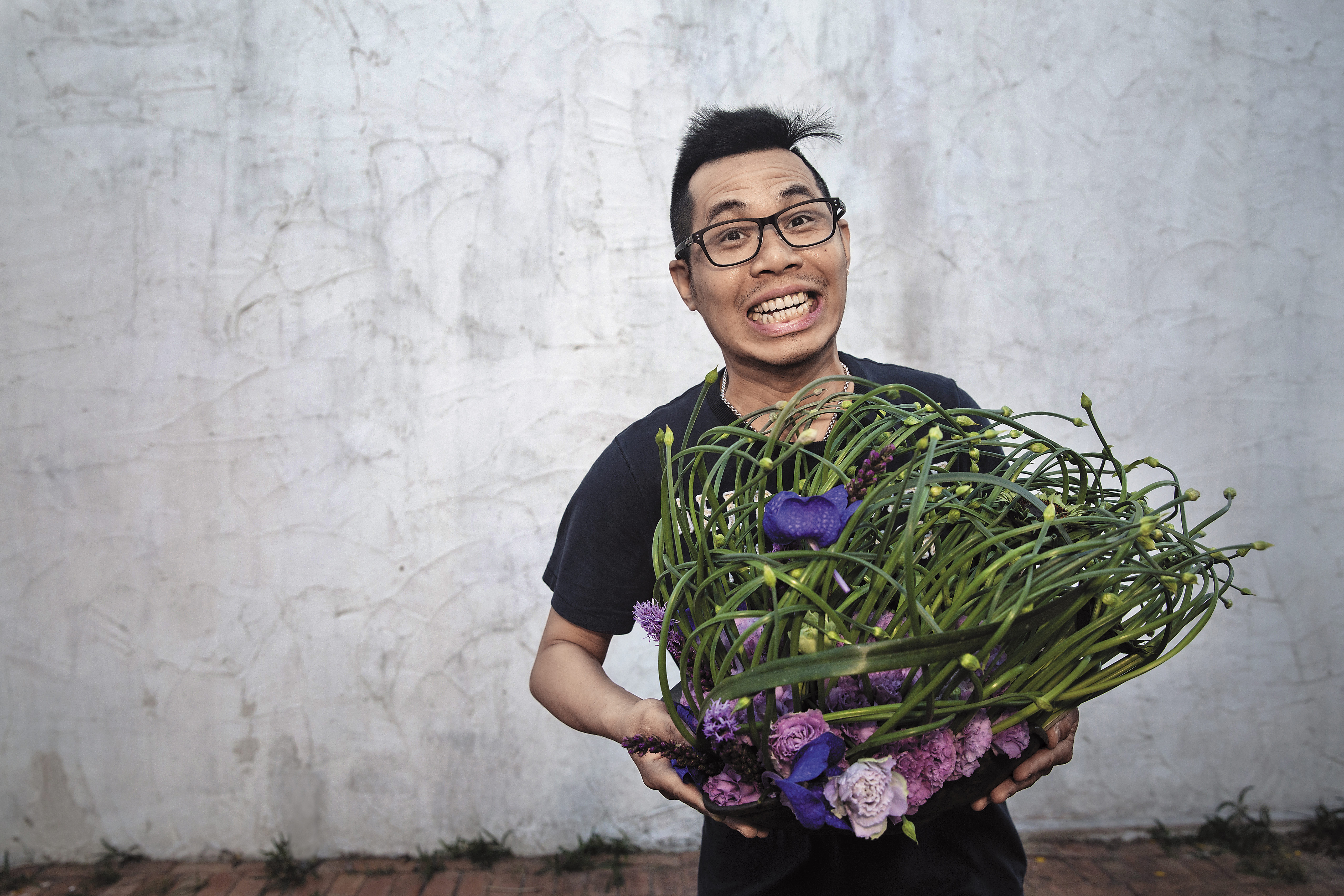 吳尚洋在墾丁民宿為我們插一盆花，彎彎亂亂的韭菜花是主角，他說3天後韭菜會開花，作品會有截然不同的風貌。