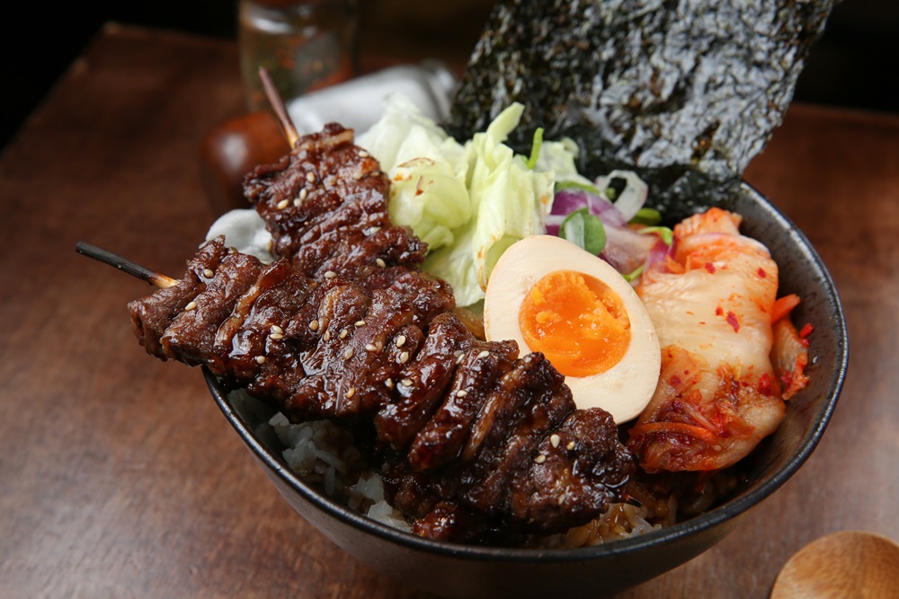 「牛肋串燒肉丼」的牛肉烤得鮮嫩不柴澀，一旁有鹹辣的韓式泡菜提味。（180元／份）