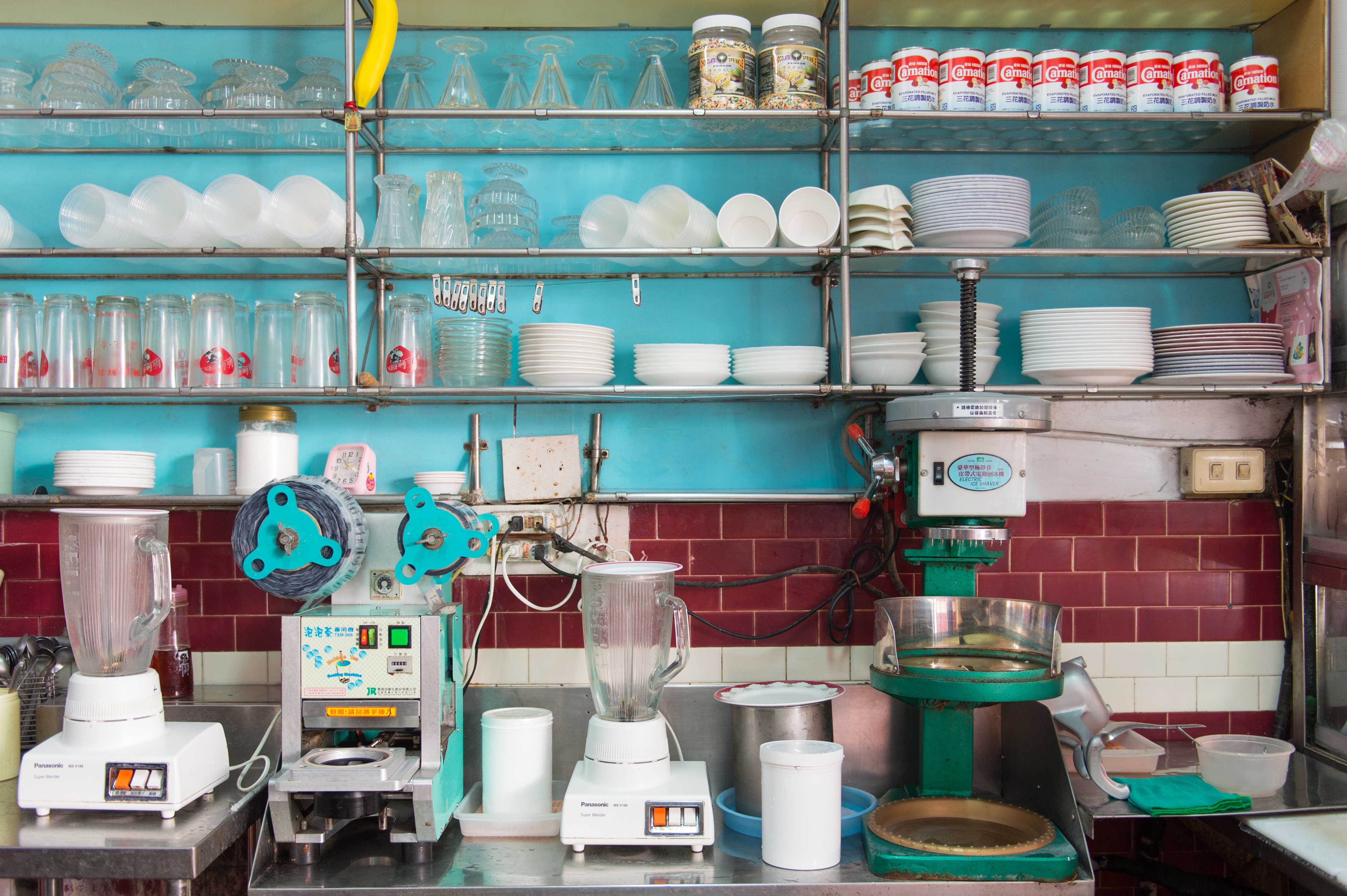 「正東山冰屋」的備料區架上擺滿玻璃聖代杯和500cc木瓜牛奶杯等，食器都使用多年，彷彿發出一種美麗的時間光芒。
