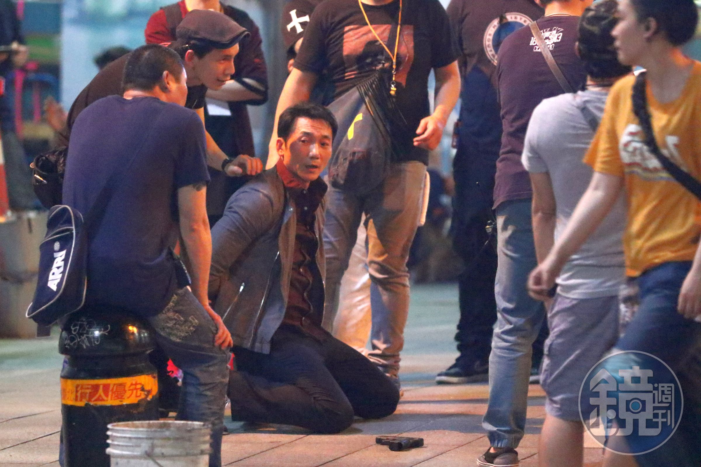 常威（鄒兆龍）在台北街頭下跪，臉上表情猙獰。