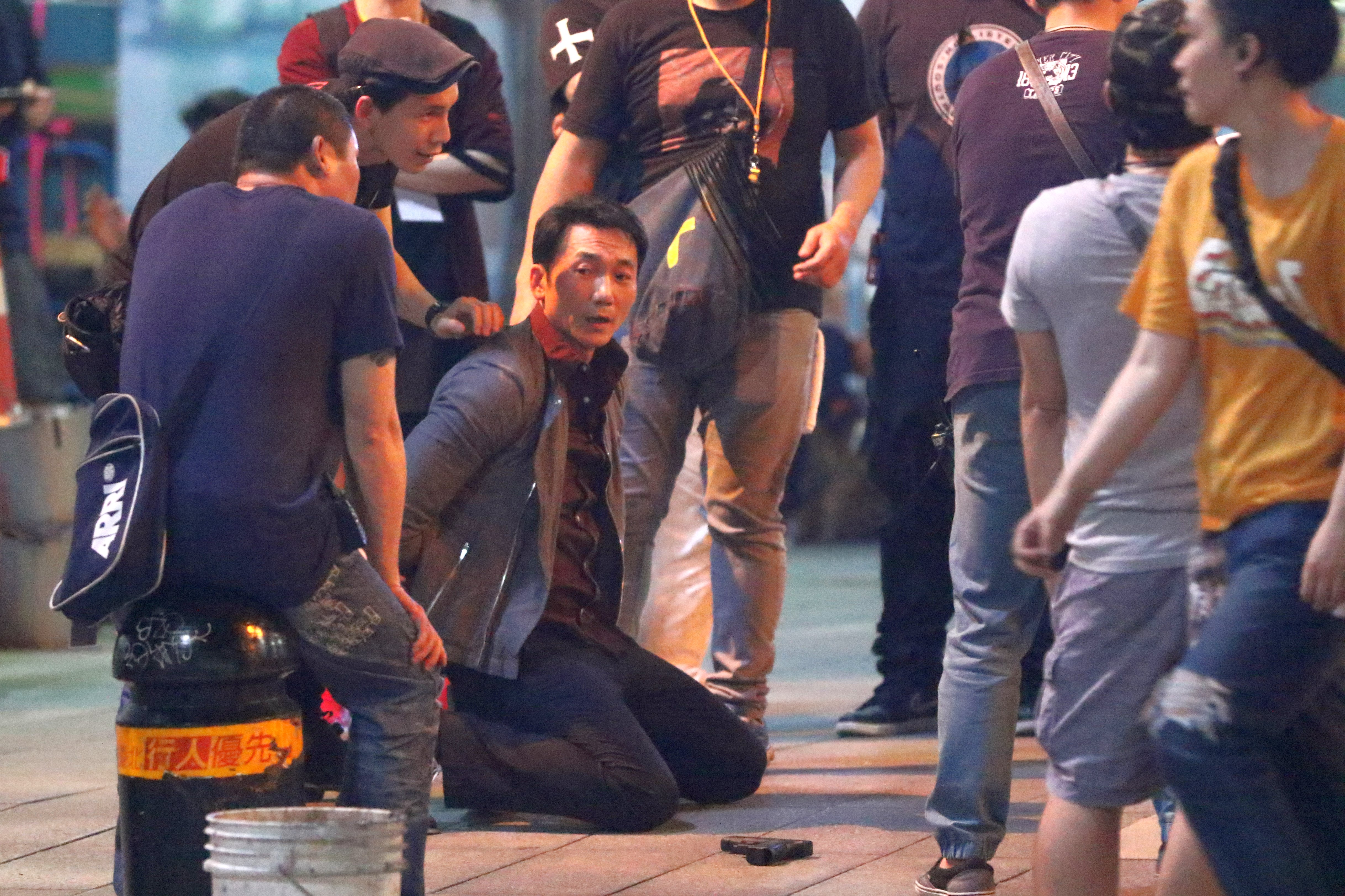 常威（鄒兆龍）在台北街頭下跪，臉上表情猙獰。