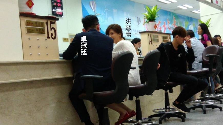 立委洪慈庸與台中市新聞局長卓冠廷到北屯戶政事務所辦理結婚登記手續，兩人濃情蜜意，羨煞旁人。（讀者提供）