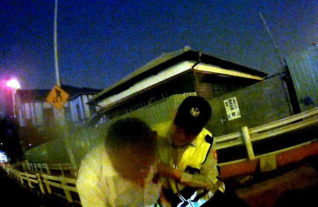 男子走路時因低頭看相機，不慎跌落到約成年男子胸口高度深的坑洞中，所幸遇到執勤員警將他救起。