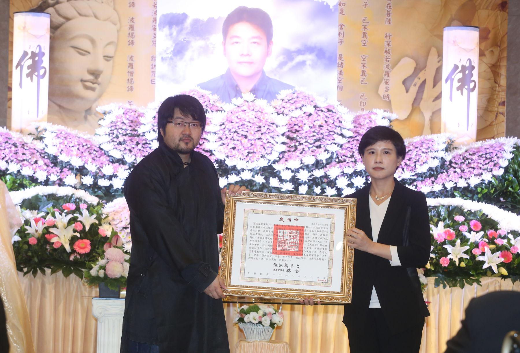 文化部長鄭麗君（右）代表總統蔡英文頒發褒揚令予鄭問，由鄭問兒子鄭植羽代表接受