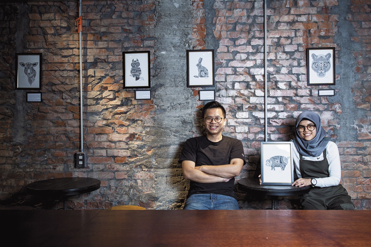 李庚羲（左）和印尼看護安妮（右）因二瓶水變成好友，安妮日前在李庚羲咖啡館開畫展，她說台灣的雇主、朋友對她很好，知道豬在台灣是很重要的食物，篤信回教的她特別畫一隻豬送給台灣人。