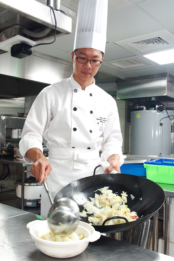 主廚盧文祈正在烹調宜蘭名菜「古早蛋酥西魯肉」，動作迅速，鍋氣十足。（宜蘭傳藝老爺行旅提供）