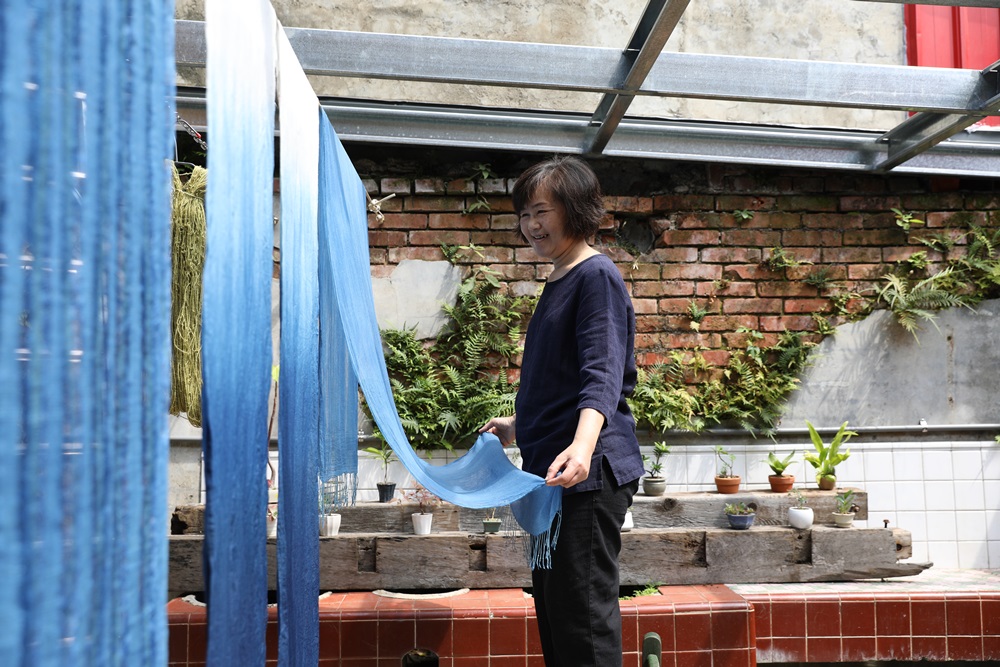 老屋後院別有風景，植物染藝術家曾秀寶自在晾曬染布，彷彿為天空添上色彩。