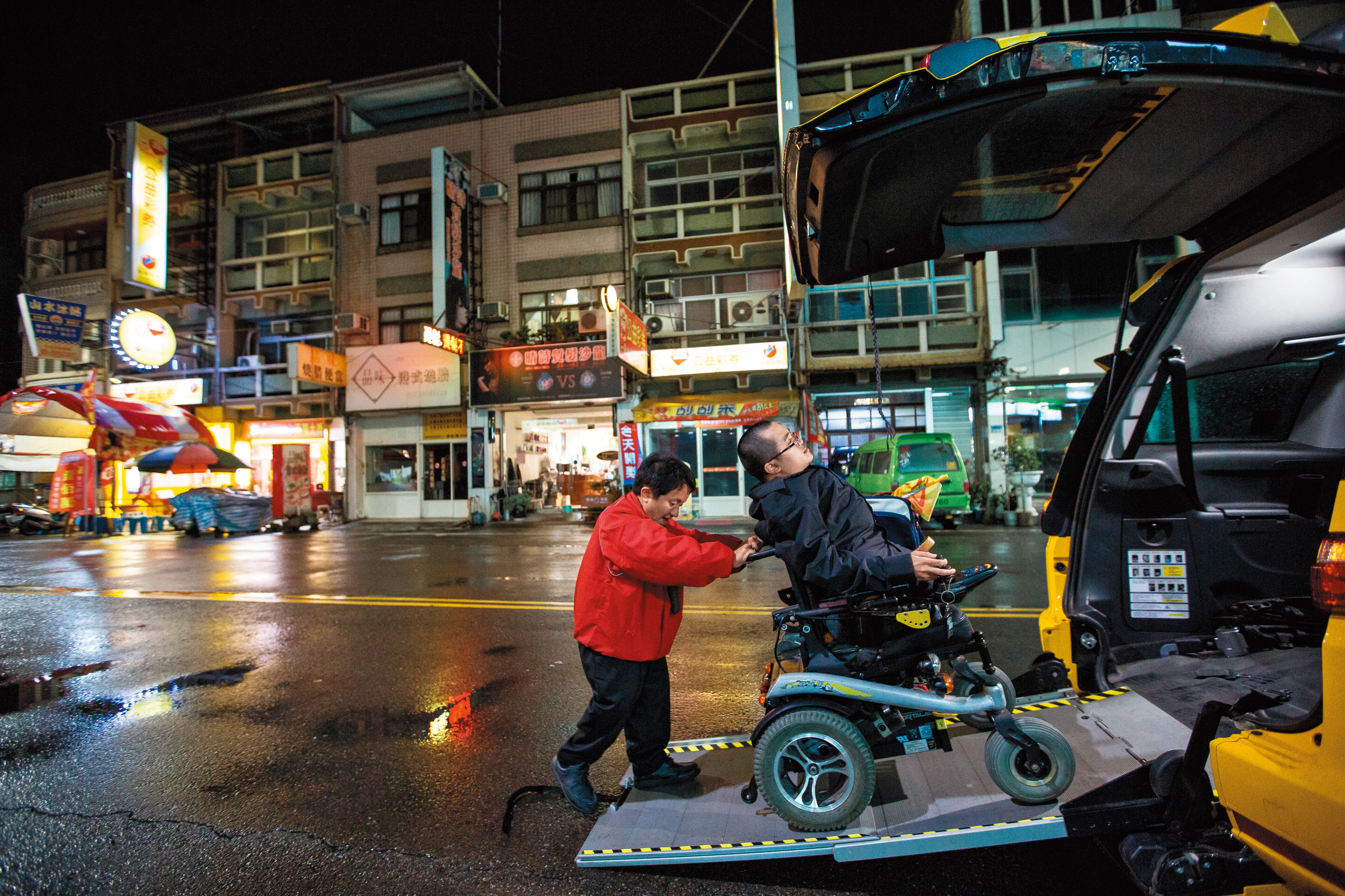 目前有三分之一客源是乘坐輪椅的客人。圖為程健智（左）協助同為成骨不全症病友陳彥廷（右）下車。