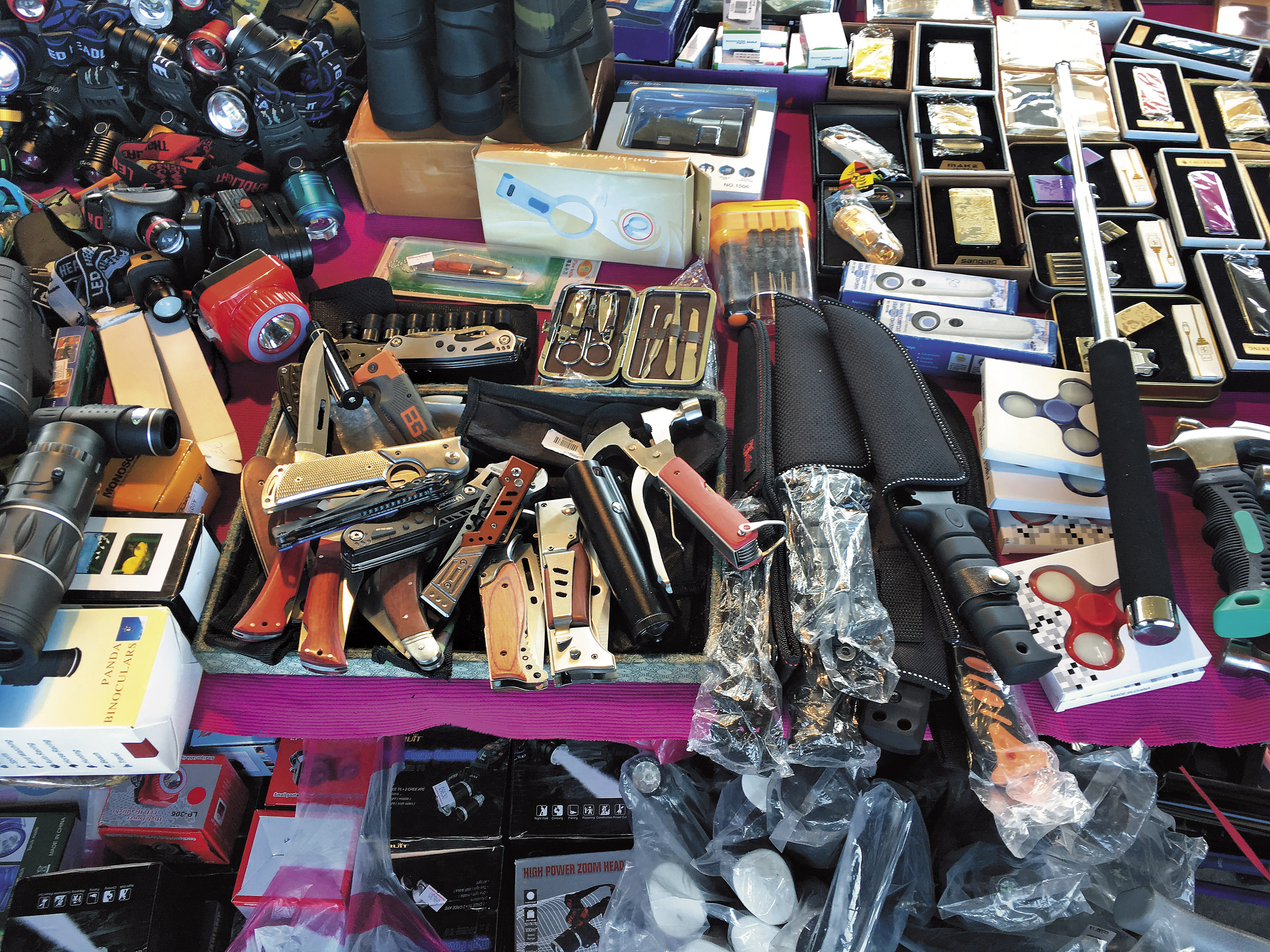 二手市集中仍有攤販賣刀械等違禁品，不少年輕人還拿來把玩。