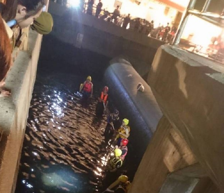 重度智障的陳男被發現時，已經陳屍河渠中，警消派員打撈屍體。