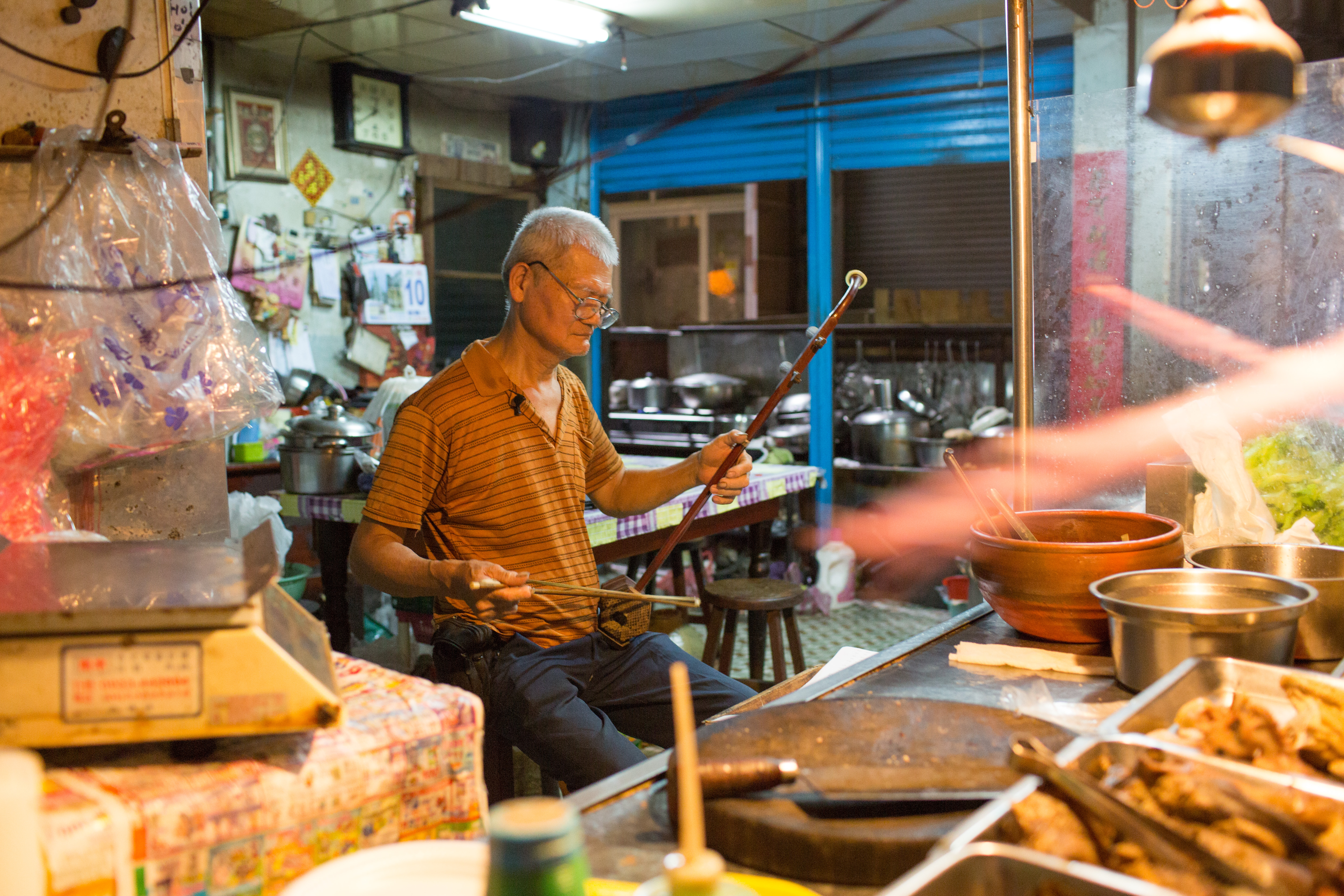 不剁雞肉的「雞肉王仔」，有時會拿起自己手工製作的二胡，拉上幾首樂曲，這幕「雞肉攤上的二胡手」場景超魔幻。