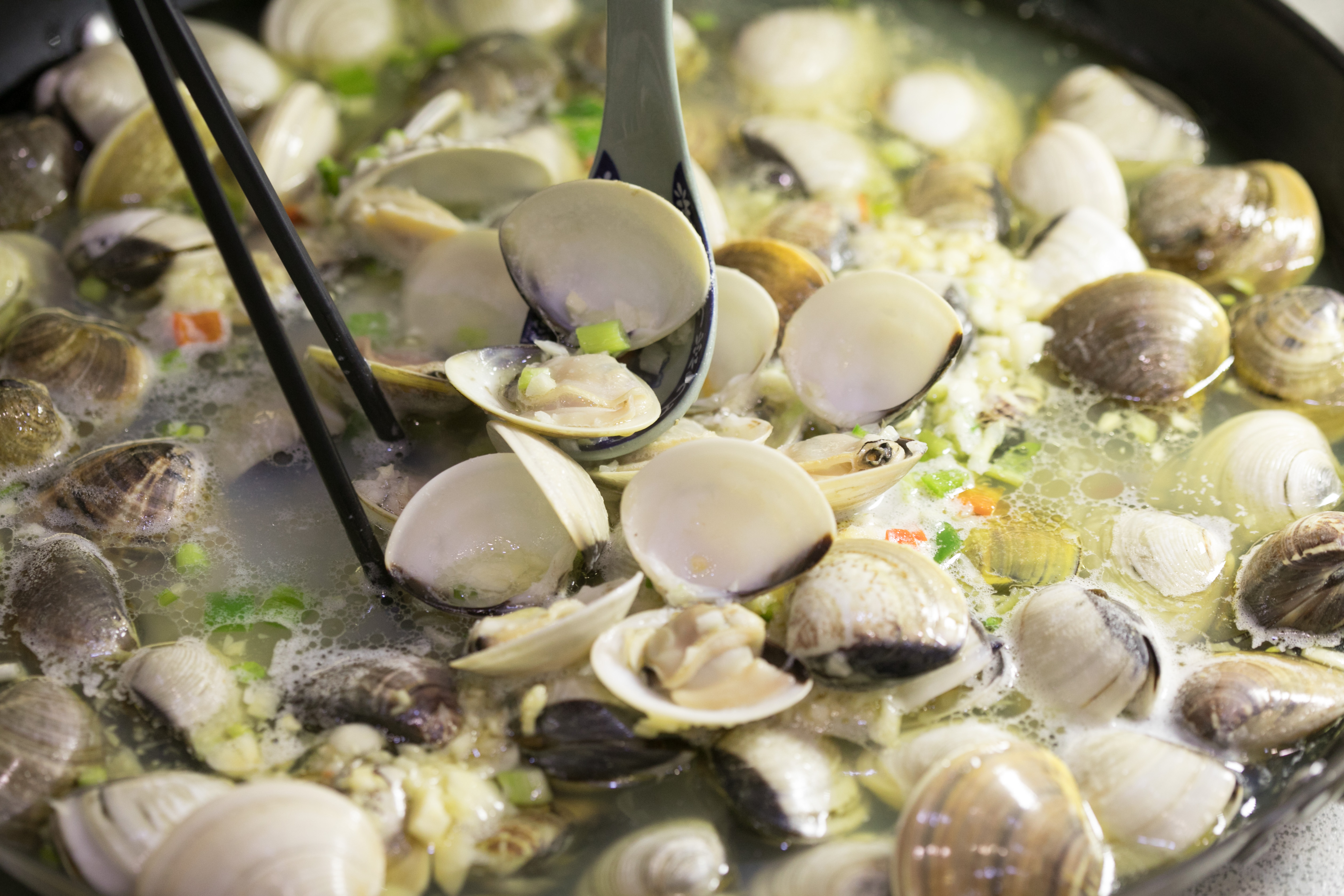 上百顆鮮蜆在鍋子裡發出卜卜聲響，看起來就好誘人。