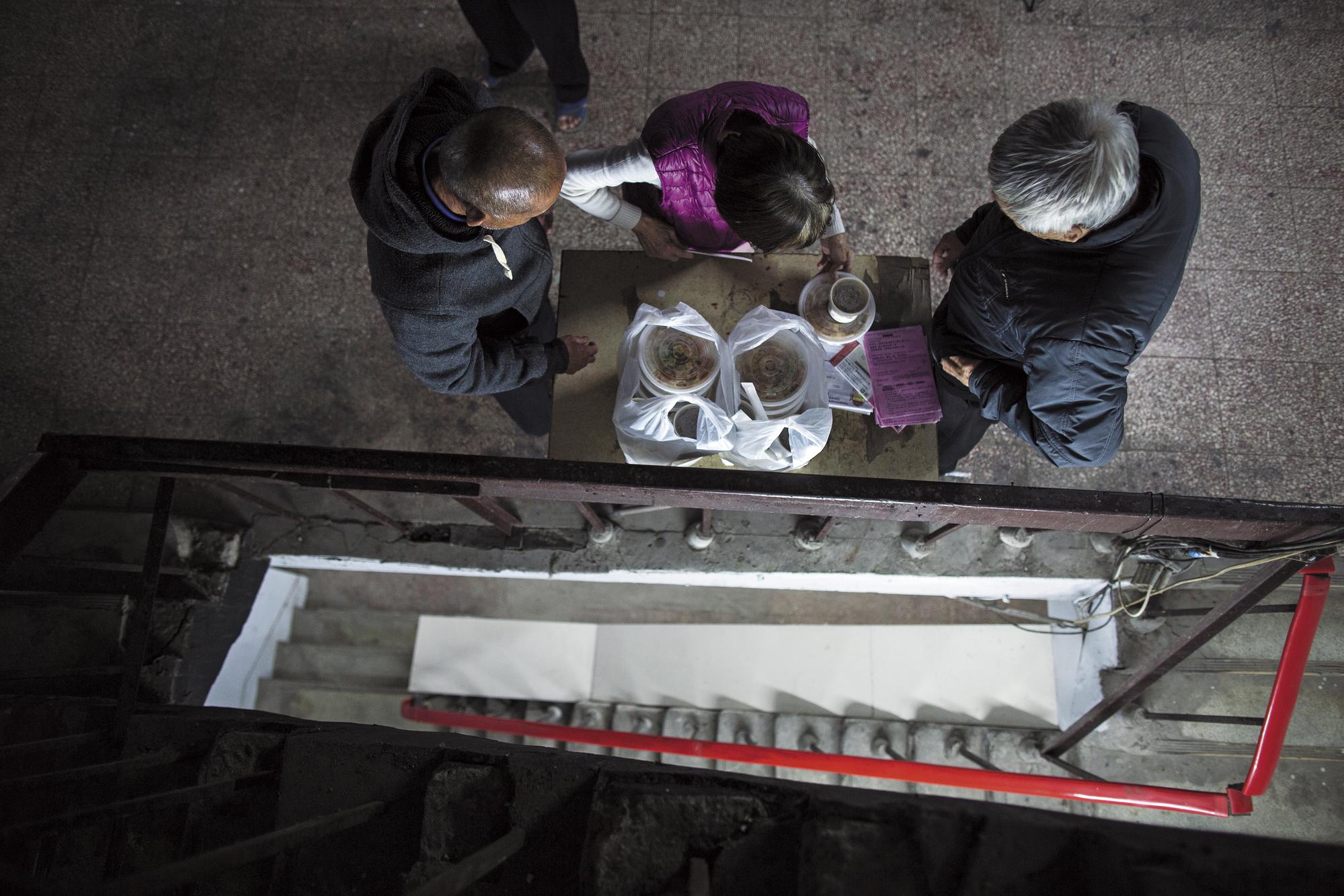 上午11點半,三重區公所及華山基金會聯合送餐,獨居長者紛紛從房內出來寒暄領便當。