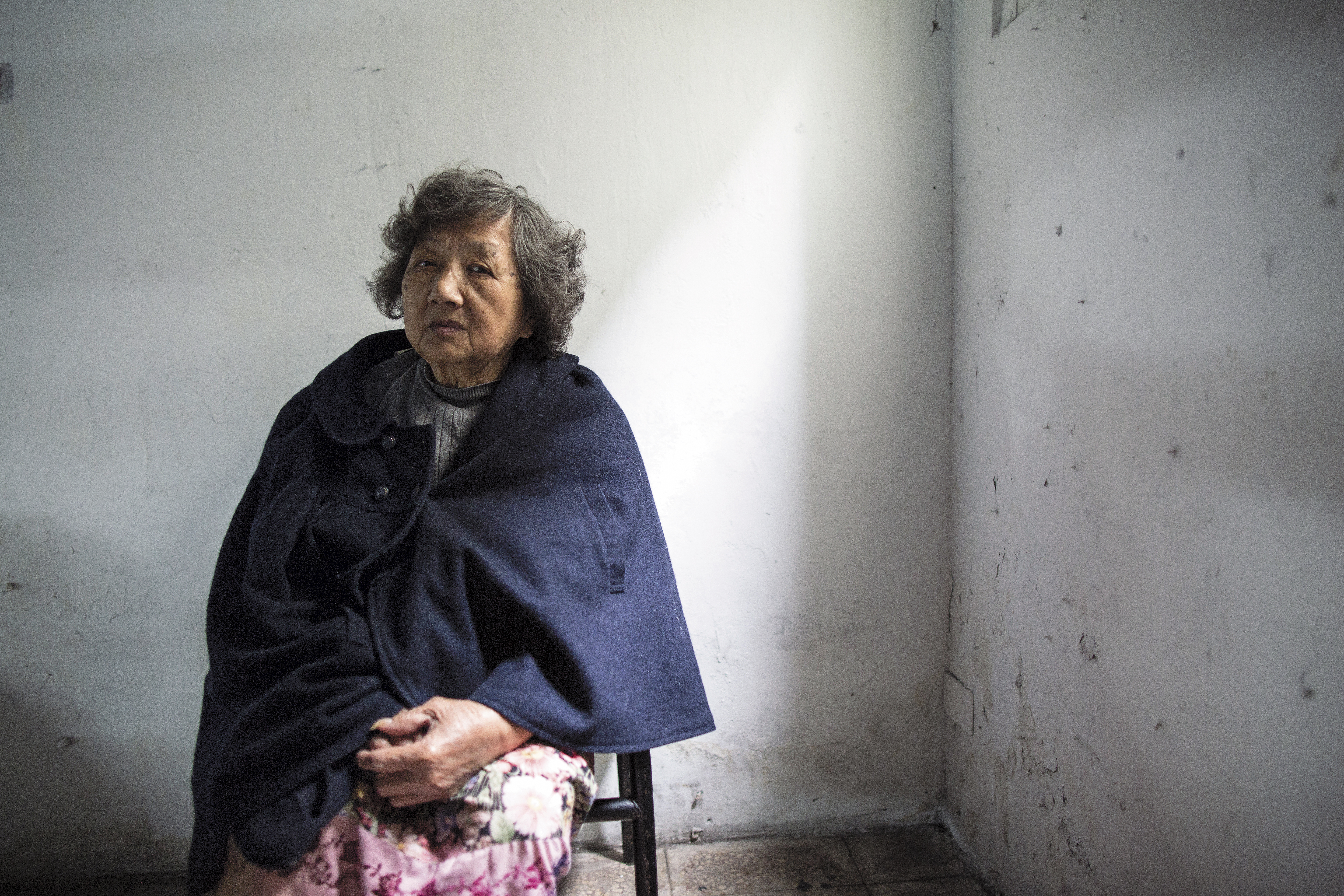 80歲的張麵在2樓等待送餐便當,身上穿的是她不能做工後,改行擺攤賣剩的洋裝。