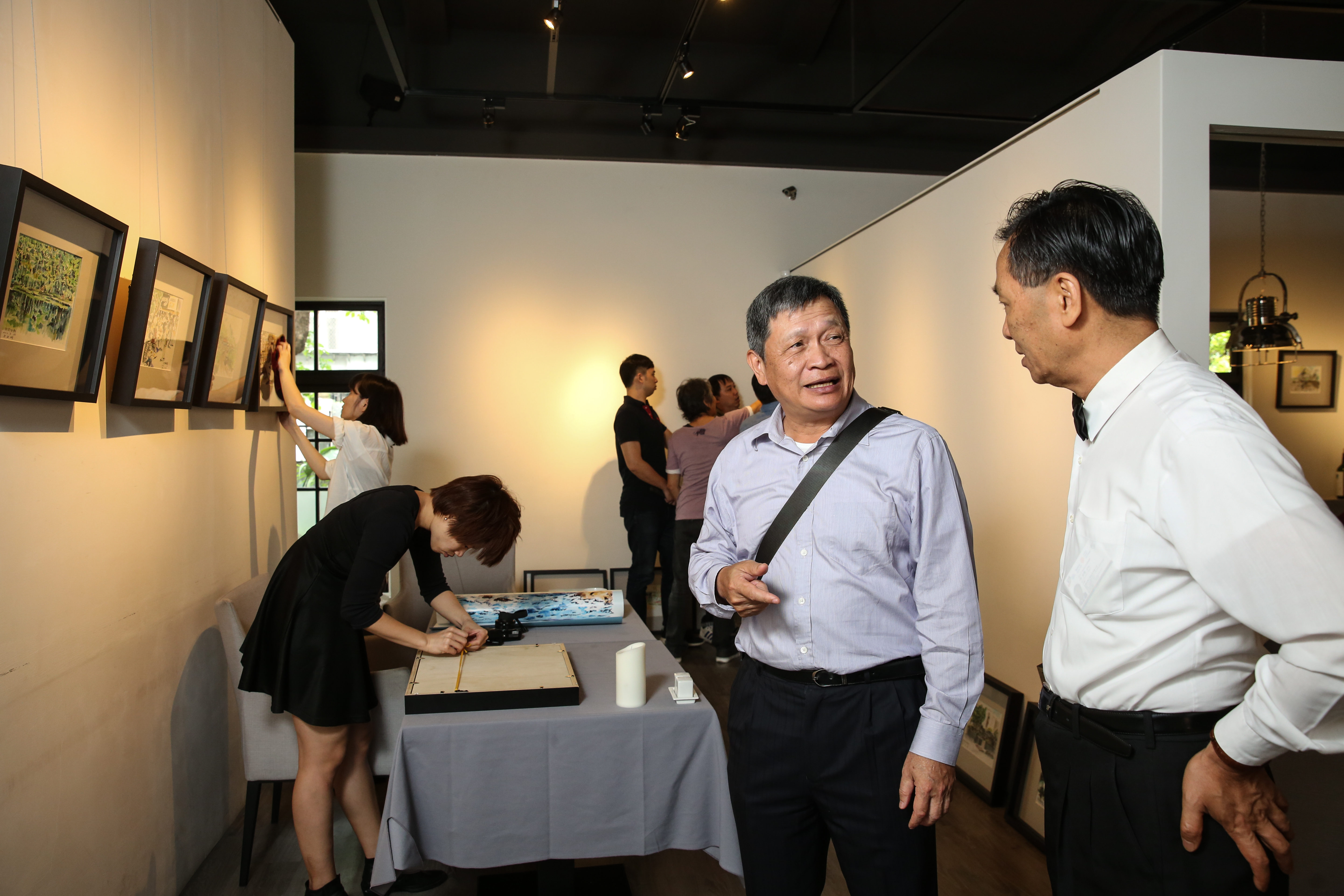 佈展當天，王正明（中）親自到場與沾美藝術庭苑總經理陳登壽（右）討論。