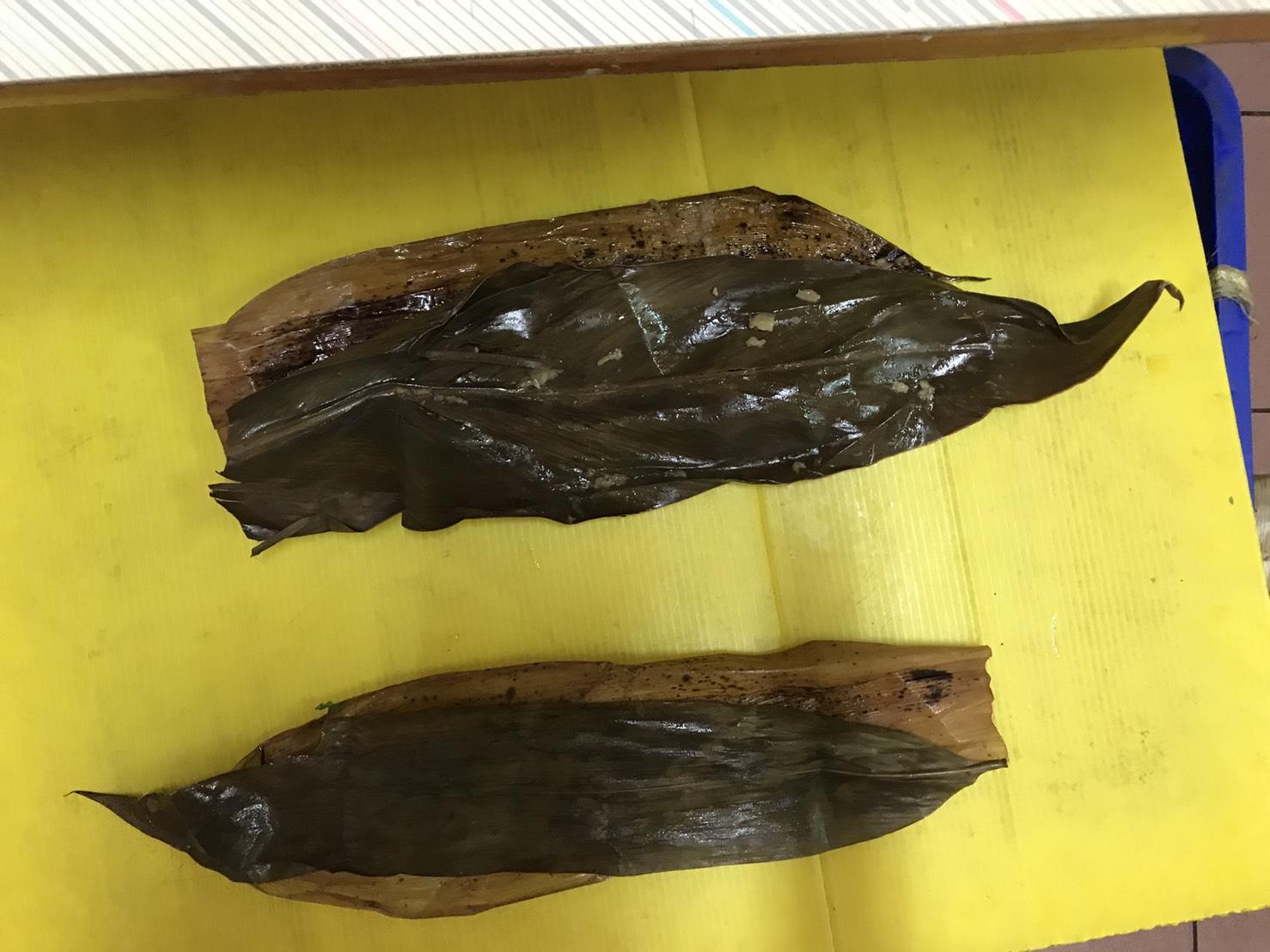 店家打開粽葉跟我解釋，「底層的竹葉用來識別這是肉粽，但中間夾入月桃葉菜（上）或竹葉（下）正是給粽子帶來不同味道的關鍵。」
