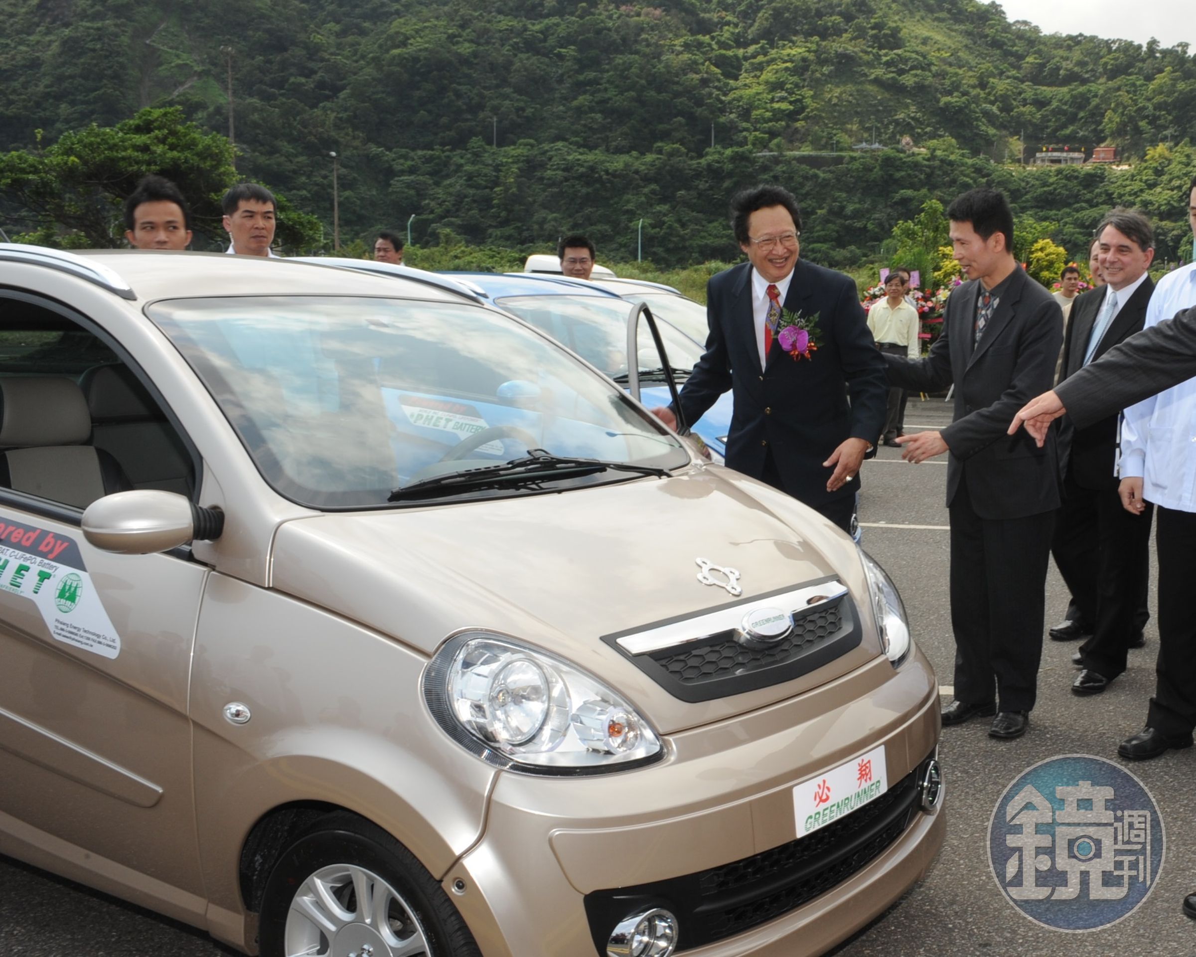 電動車大廠必翔股價連番重挫，董娘伍蔣清明今日出境遭攔。圖為創辦人伍必翔（開車門者）介紹自家電動車。（翻攝自行政院全球資訊網）