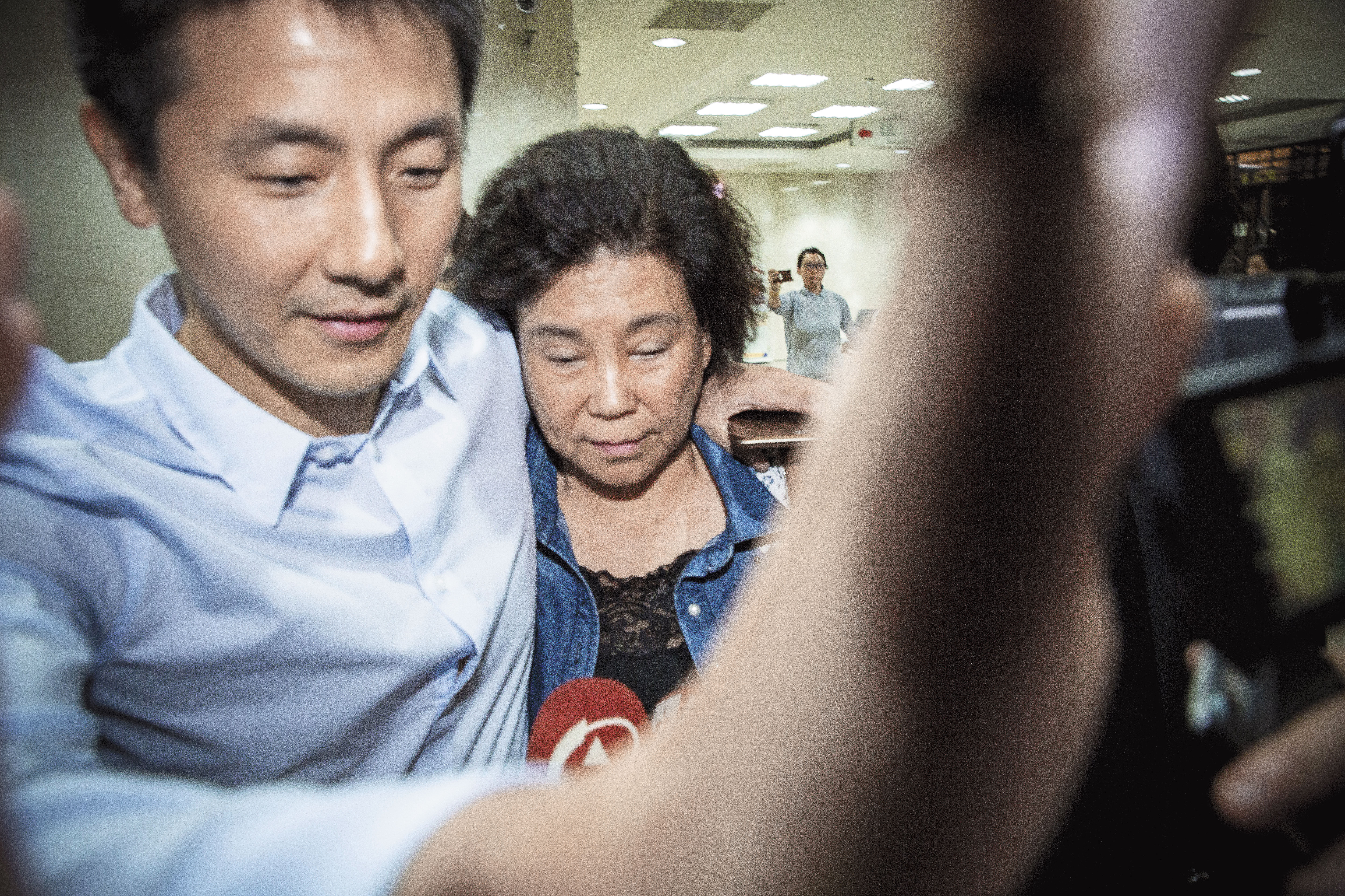 伍蔣清明(左2)交保後在親友保護下離去,對案情不願表示意見。