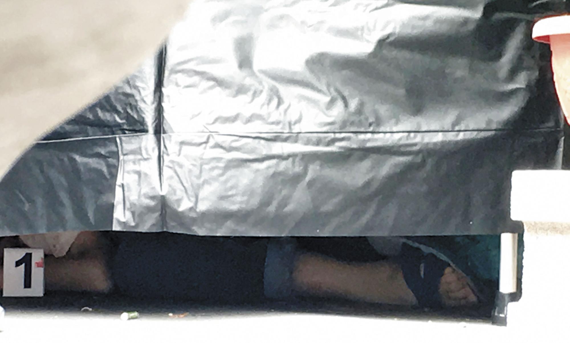 橫屍街頭的林女死後還穿著藍白拖，頭顱滾在一旁，警方趕緊圍起布幔進行驗屍。