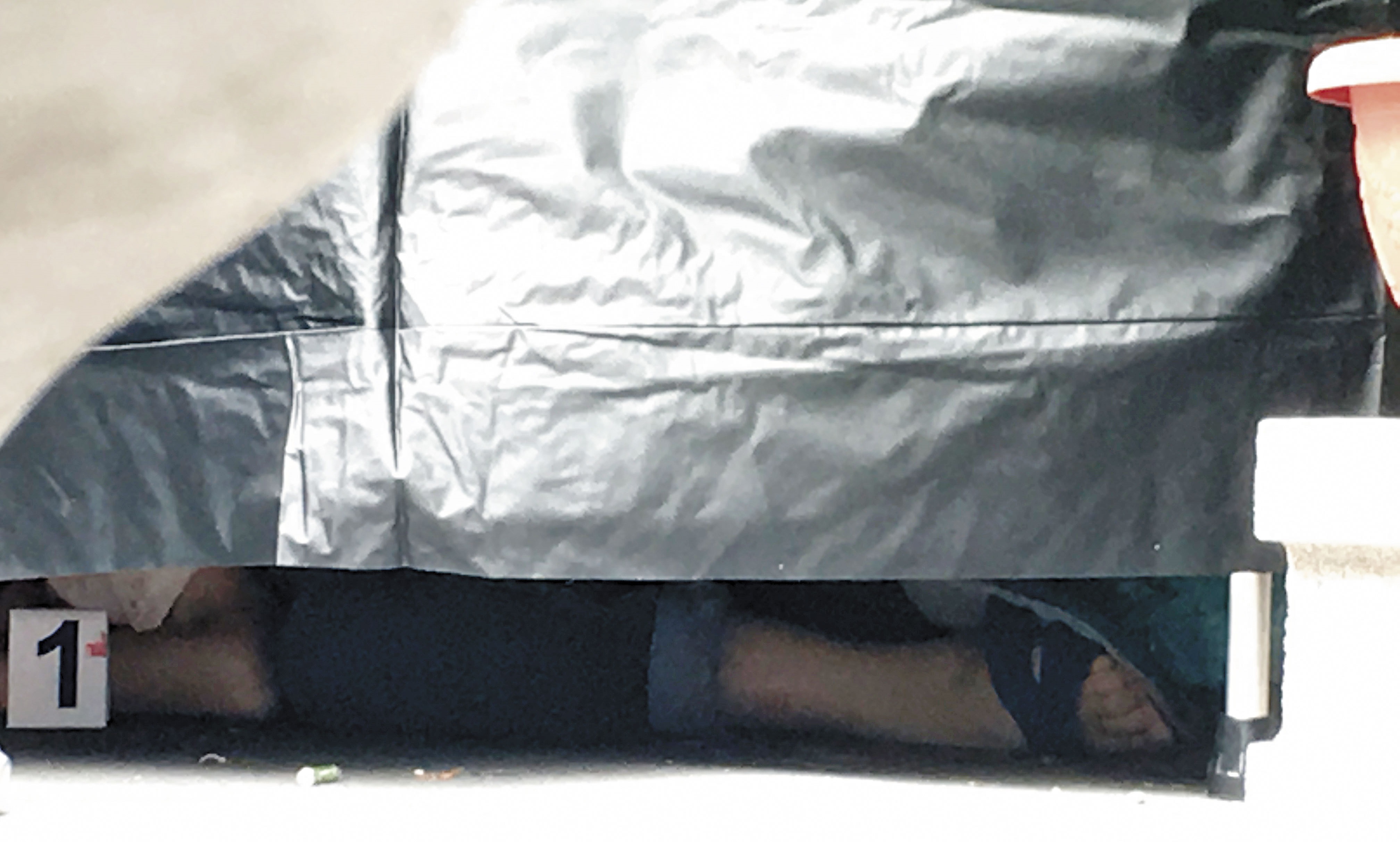 橫屍街頭的林女死後還穿著藍白拖，頭顱滾在一旁，警方趕緊圍起布幔進行驗屍。