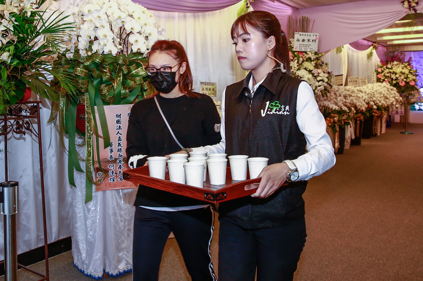 謝金晶(左)和工作人員端茶水給現場守候的媒體和工作人員。