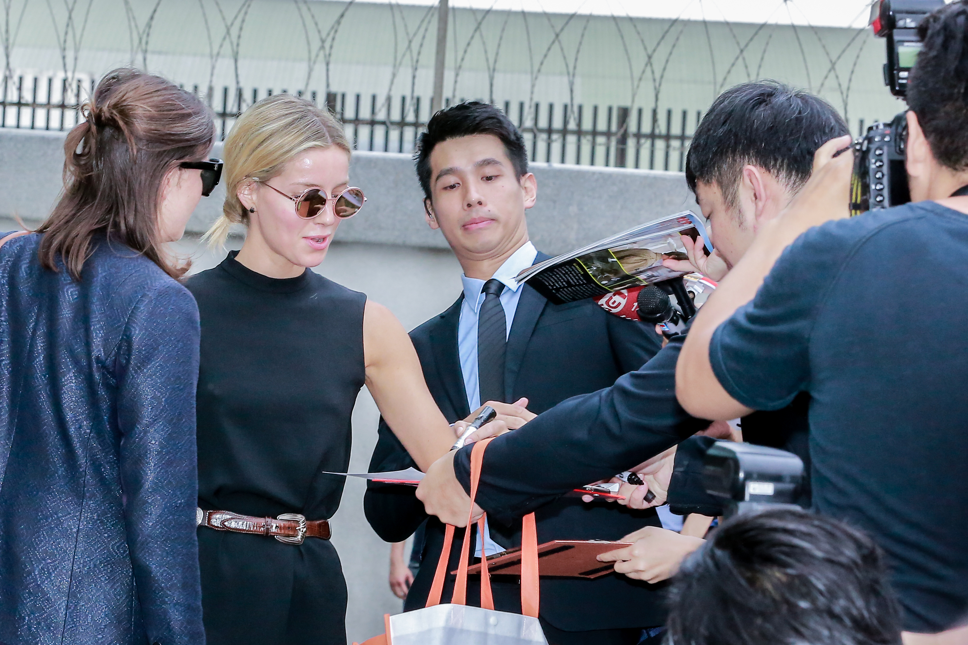 《神鬼傳奇》女主角安娜貝爾瓦莉絲（左二）正在替影迷簽名，但這位保鏢的表情好搶鏡。