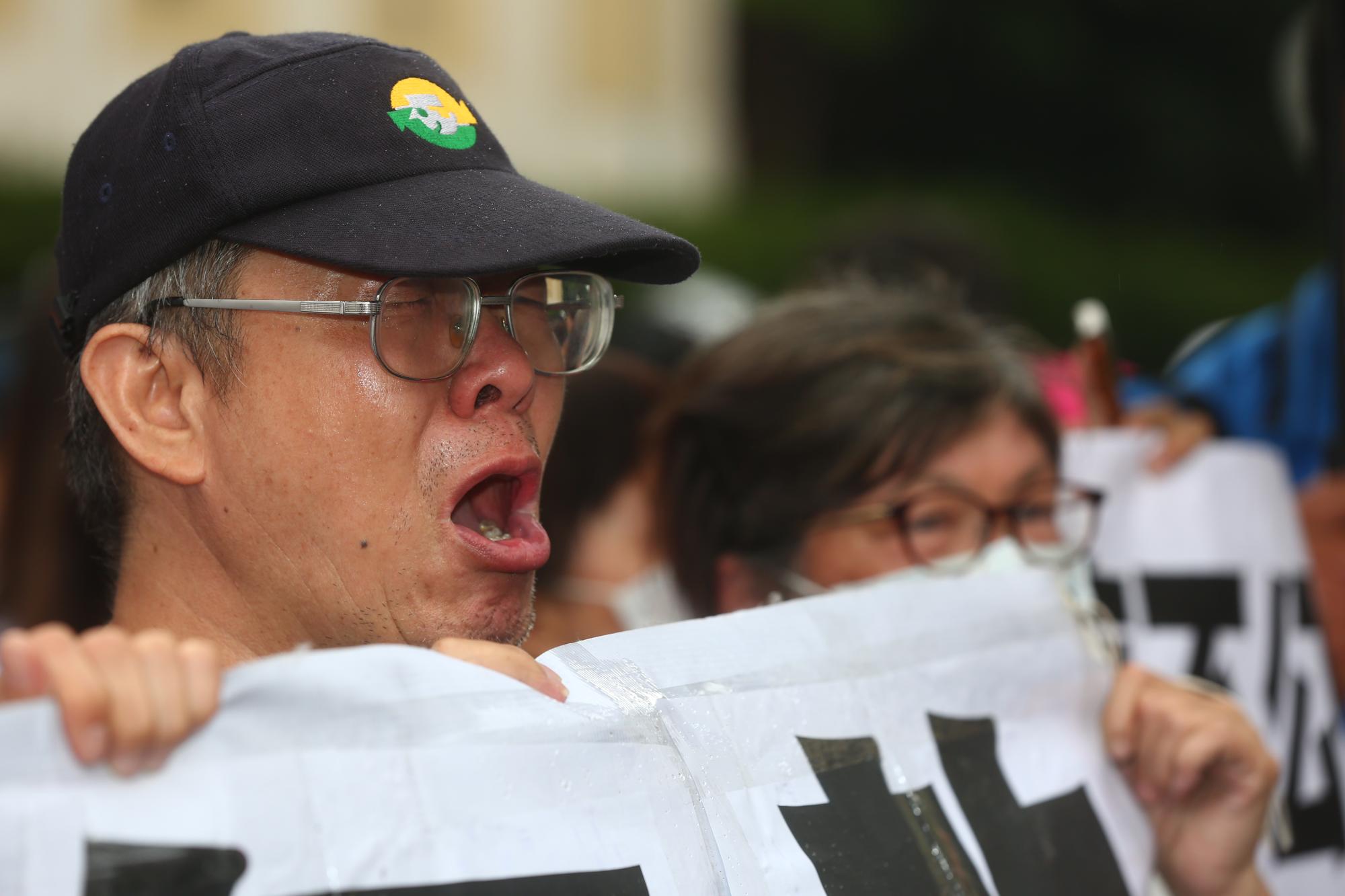 反同婚團體手舉布條在司法院大門口抗議,聽到民法違憲消息後無法接受,有人甚至哽咽哭泣。