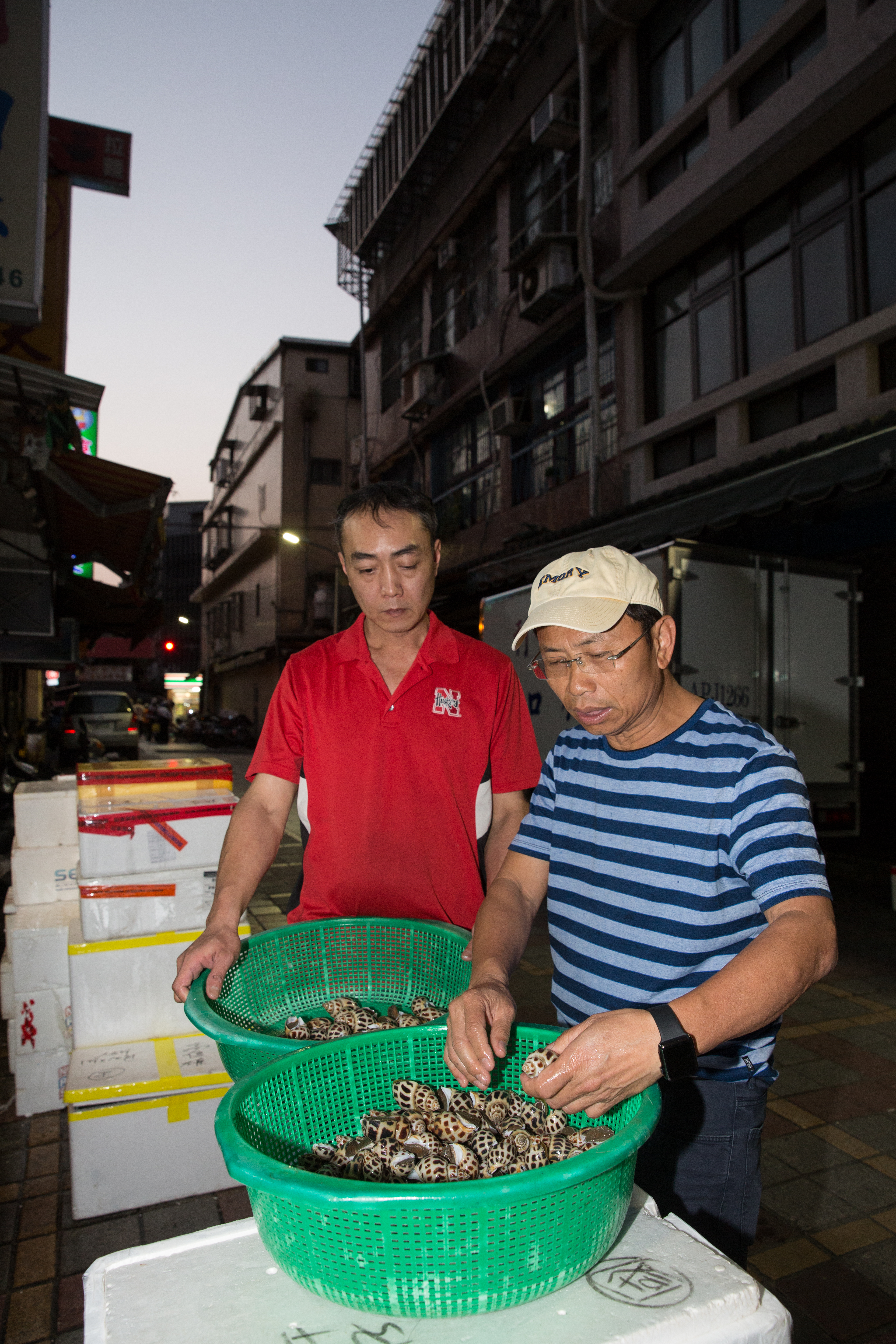 每日清晨5點,黃文童(右)都會去三水街市場上的海鮮供應商挑貨,以確保食材符合自己對新鮮度、規格的需求。