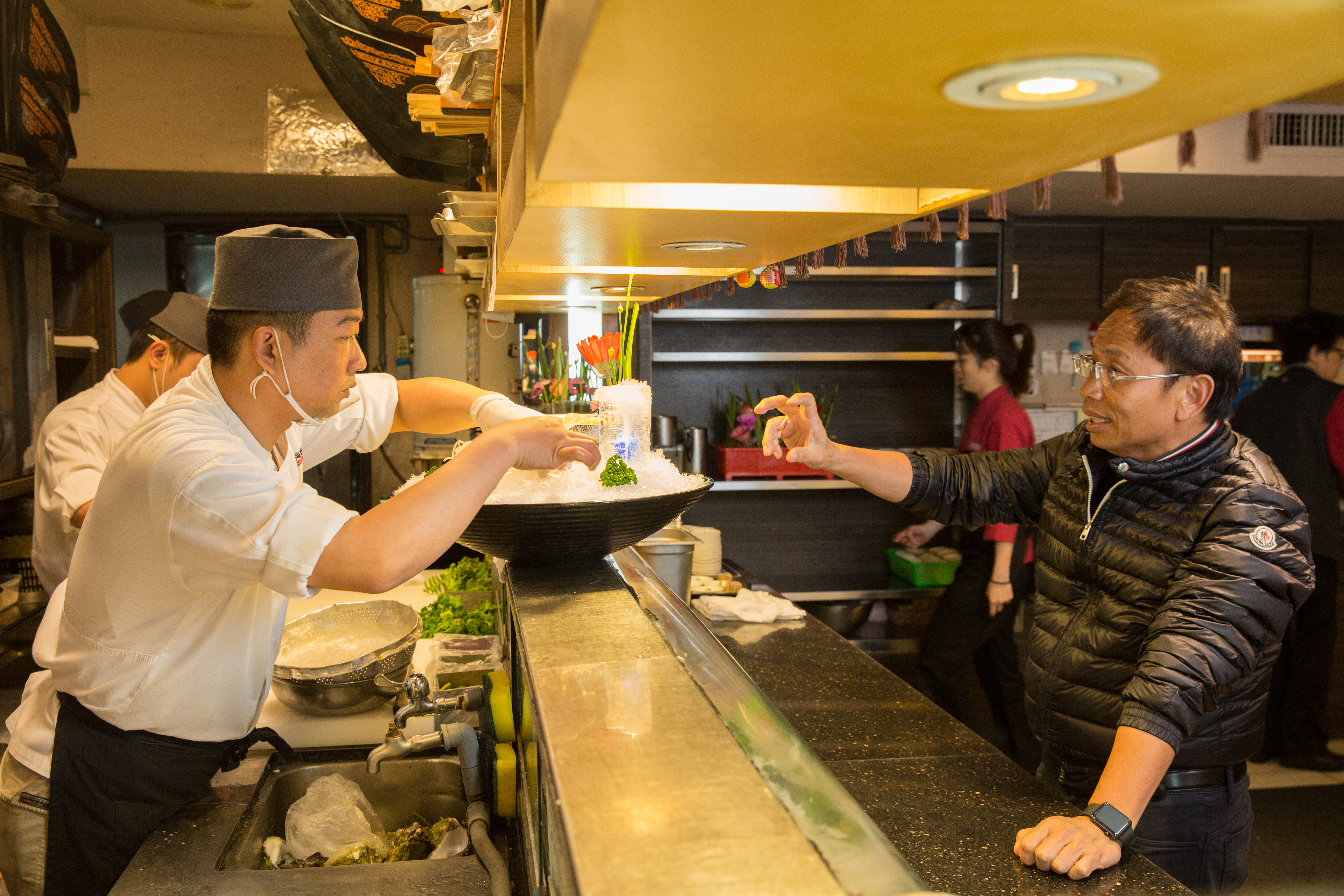 黃文童(右)在餐廳打造專屬的日本料理吧台,對食材、擺盤以及師傅料理手法的要求嚴格,也會親自指導。