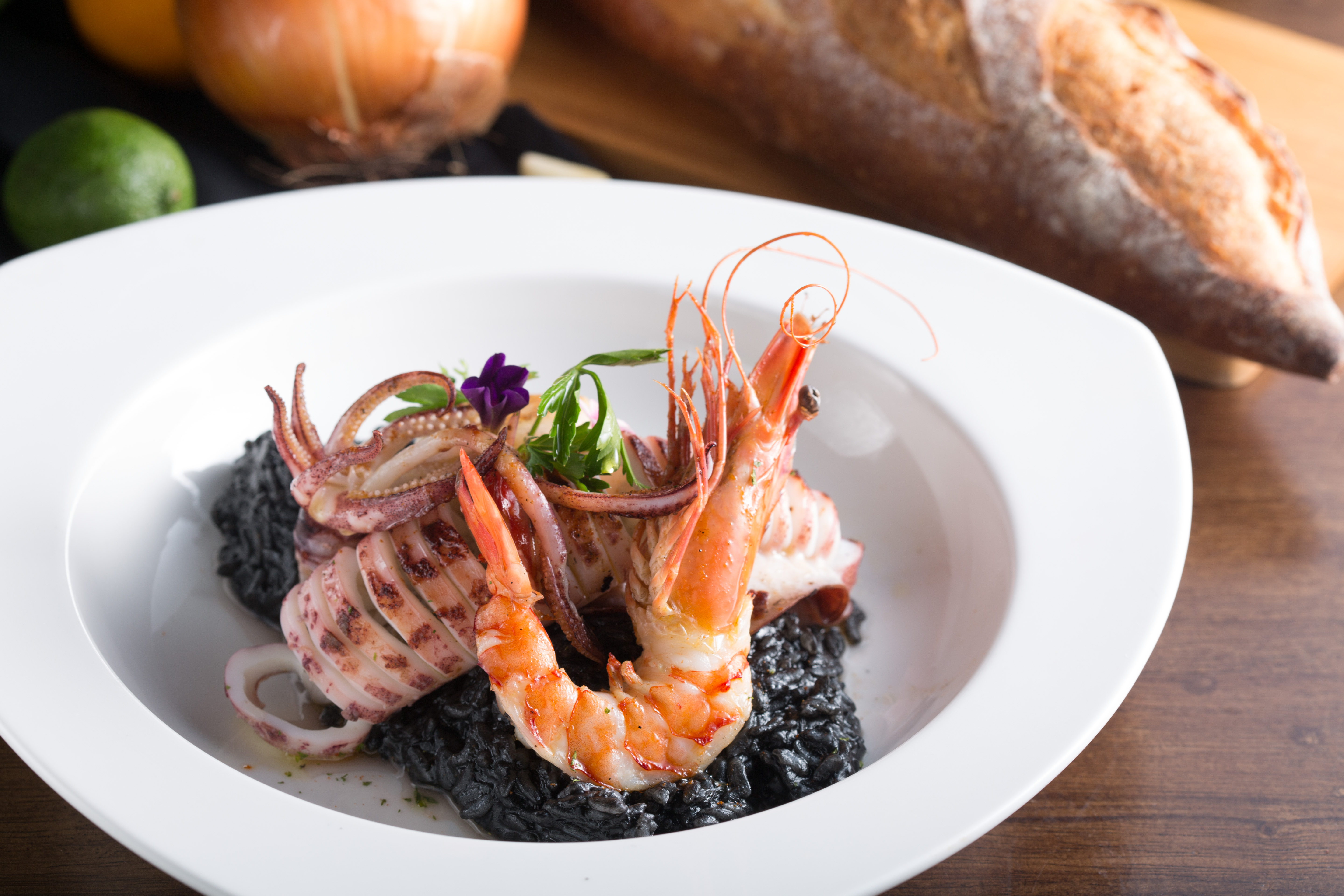 使用花蓮芋香米做成的「澎湖海鮮墨魚燉飯」，飽滿綿潤，還有一整隻彈嫰的澎湖小卷，海味鮮甜。（388元／份）