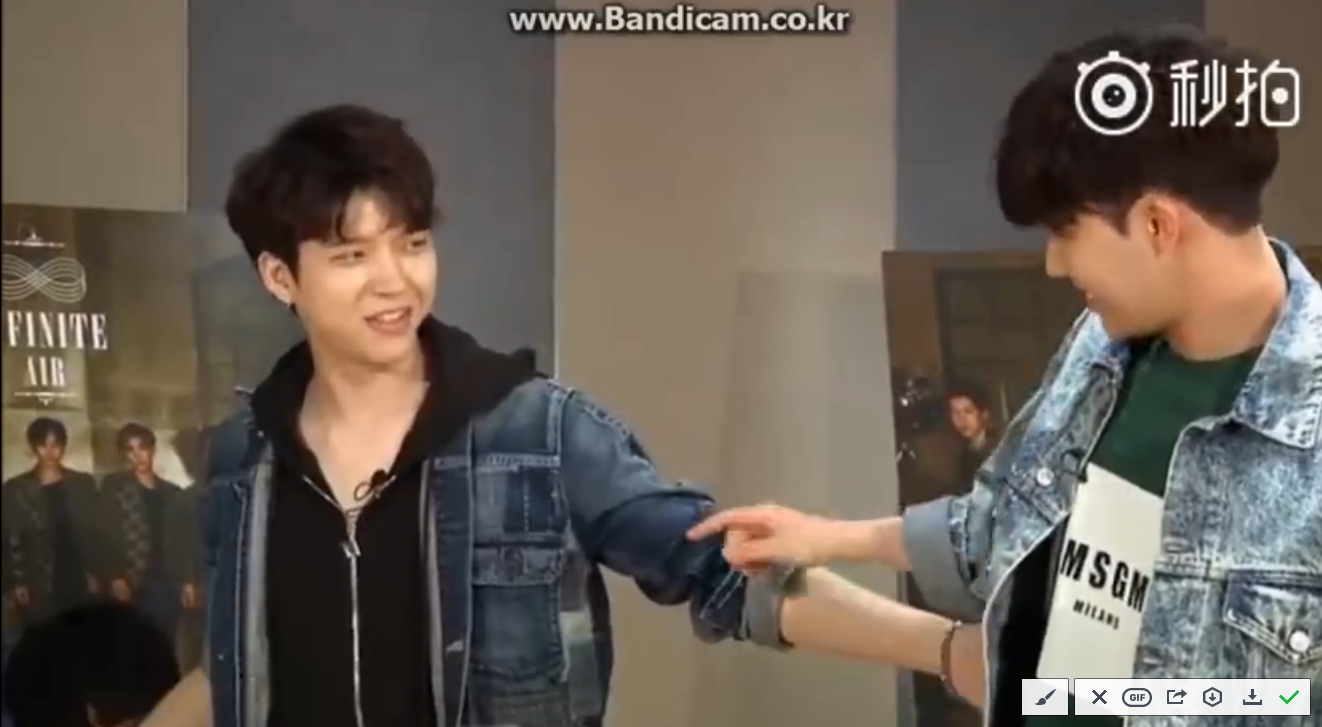 韓國男團INFINITE隊長聖圭（右）和優鉉示範一起在澡堂洗澡的情景。（截圖自影片）