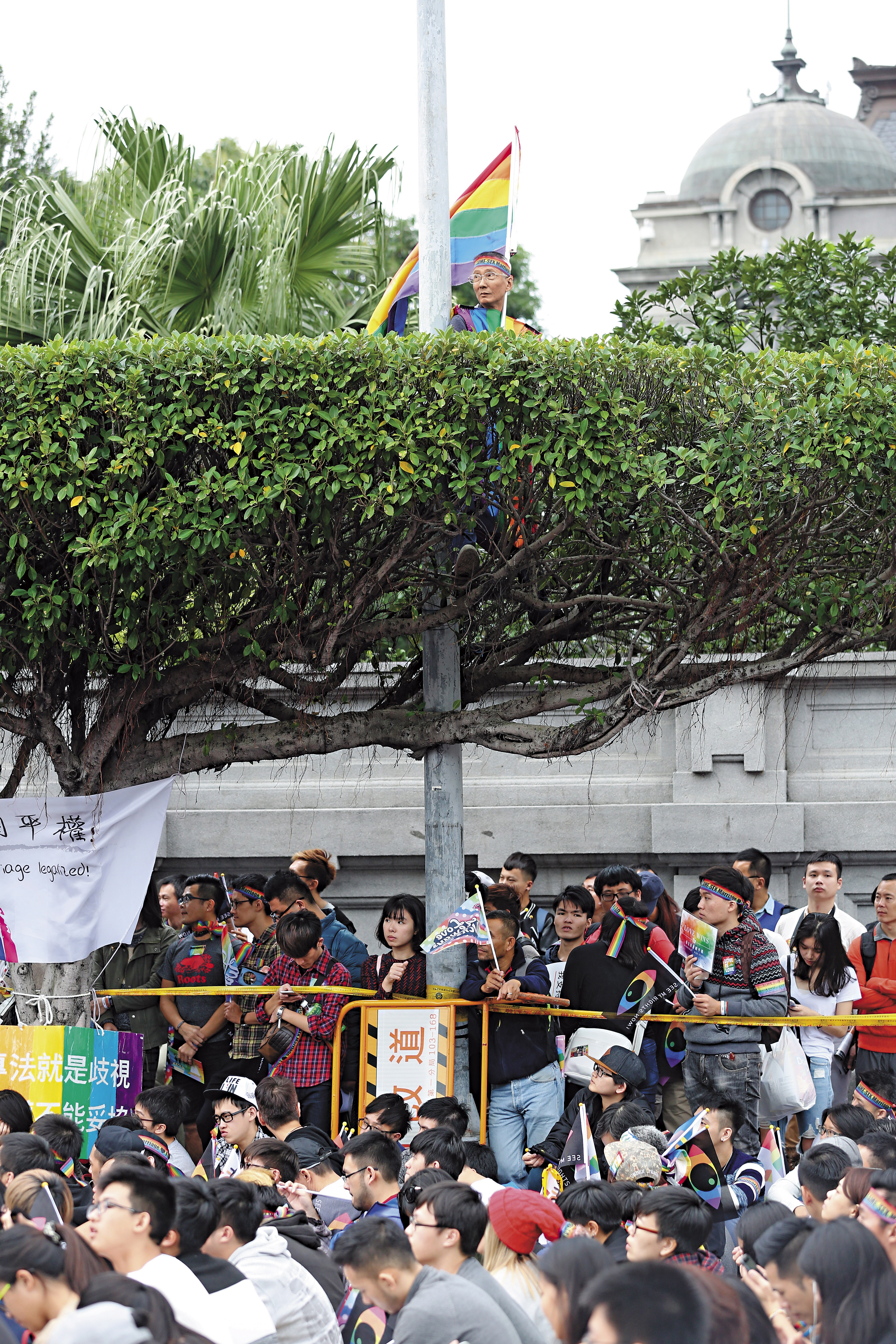 每年同志遊行或相關活動,祁家威皆手持彩虹旗,甚至身穿彩虹衣,站上制高點。(賴智揚攝)