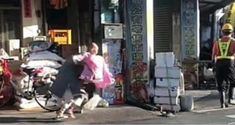 林姓比丘尼拿起垃圾，追上清潔隊員準備攻擊。