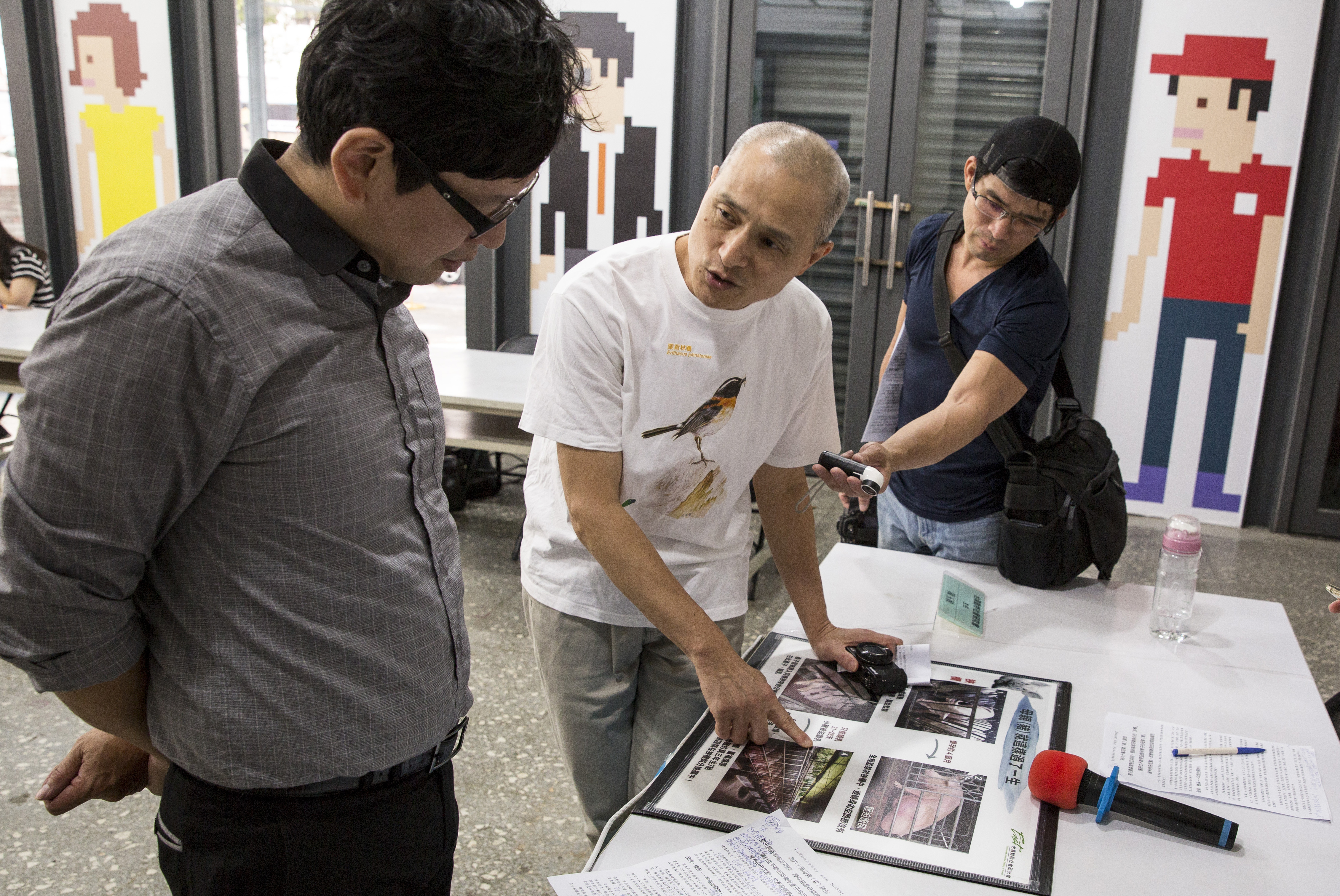 在「為母豬請命」的記者會上，朱增宏認真地為詢問的記者解釋台灣圈養母豬的困境。